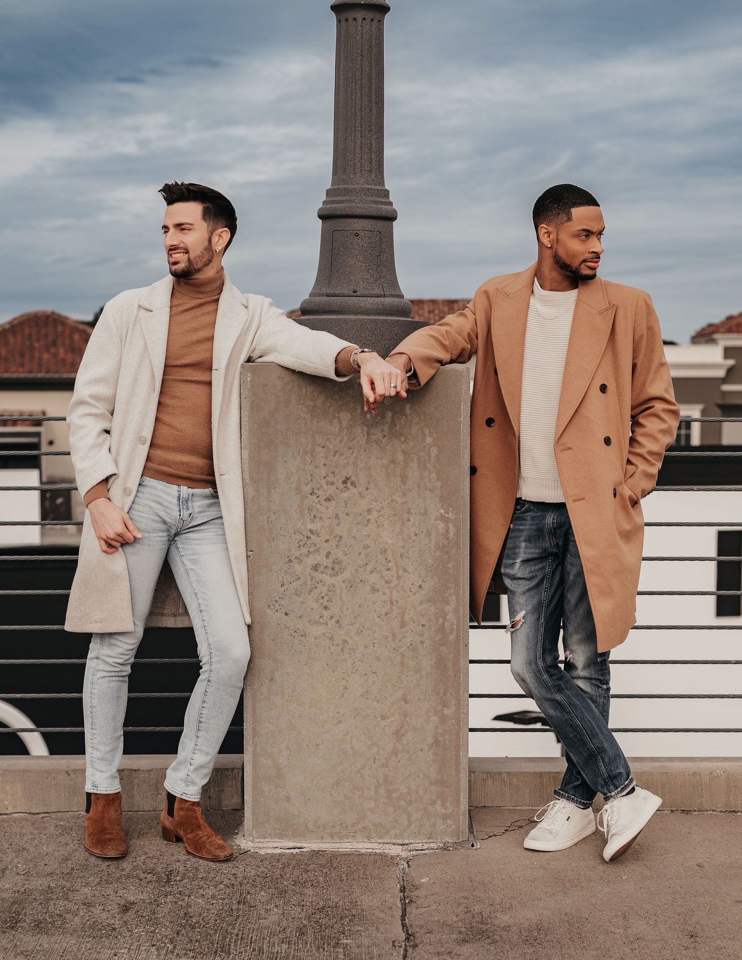 Romantic engagement portraits on rooftop parking garage overlooking Bridge Street, posing looking away from each other but touching hands