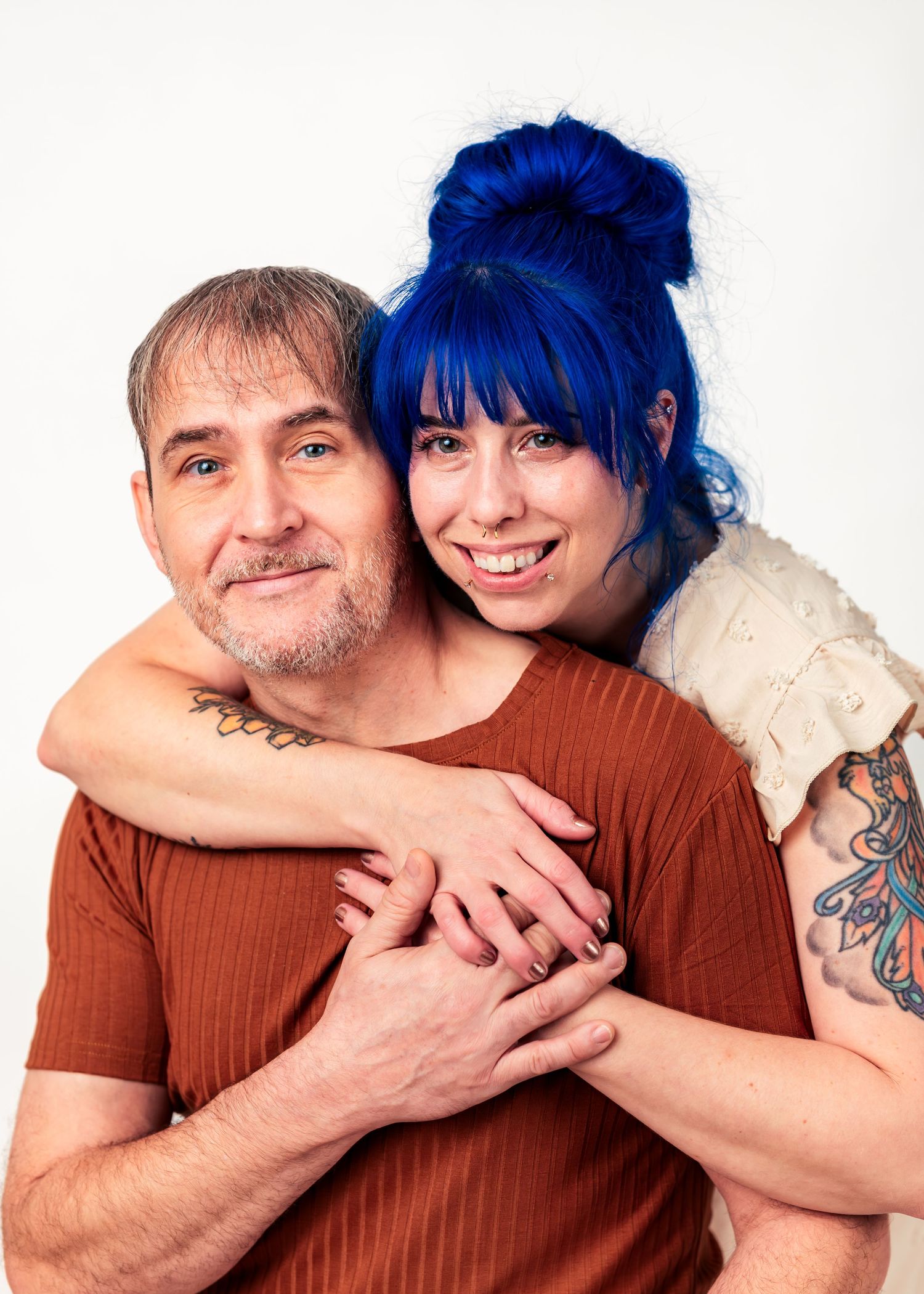 Close-up of husband and wife wedding photography duo Carolyn and Barry embracing in studio, photographed for Catch Your Fire Photography