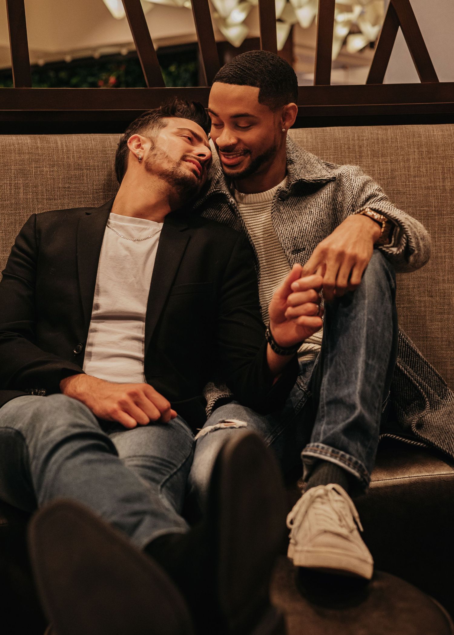 Romantic same-sex engagement portraits on the couch inside The Westin hotel lobby in Huntsville at Bridgestreet