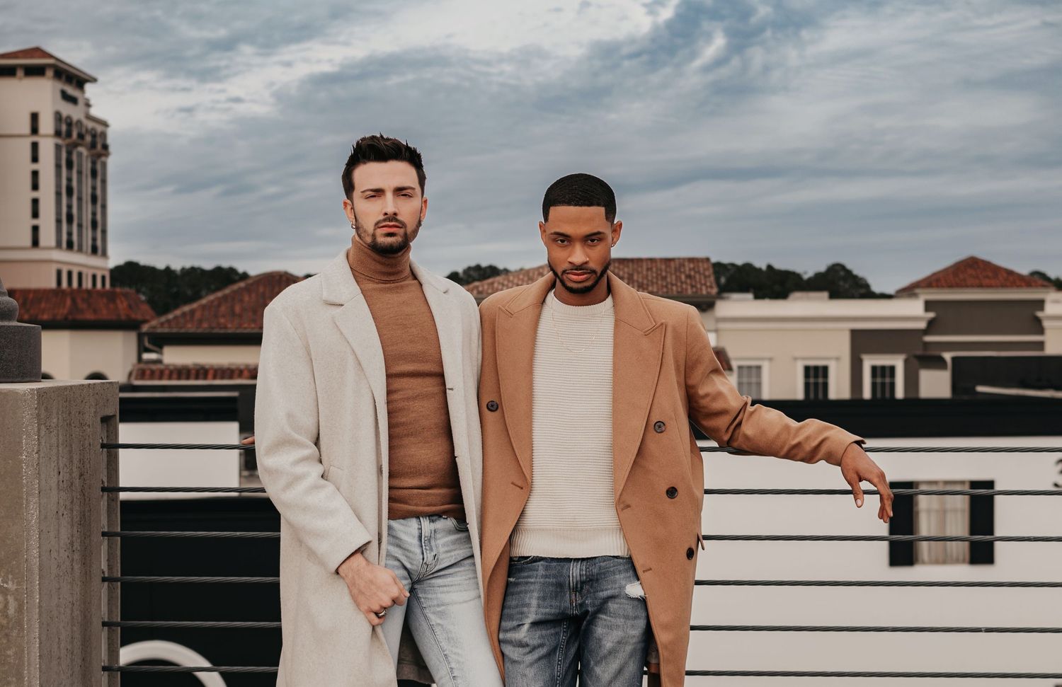 Same-sex couple hanging out on parking garage rooftop overlooking Bridge Street