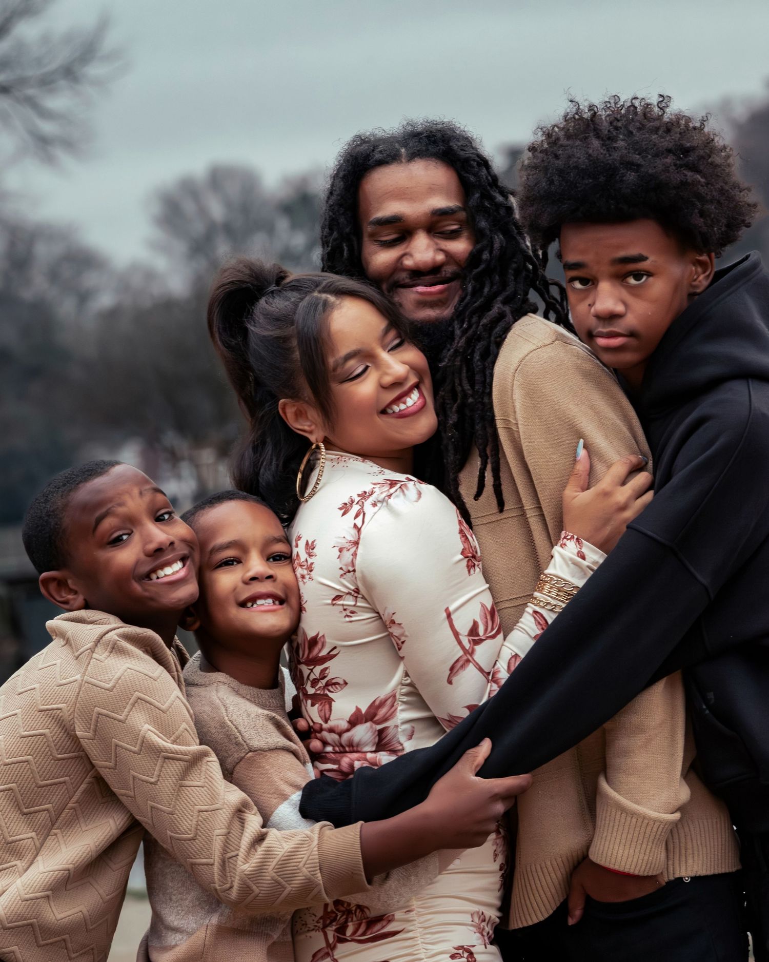 close up candid shot of African-American family having a group hug on a cloudy winter day by Lady Ann Lake in Huntsville, Alabama
