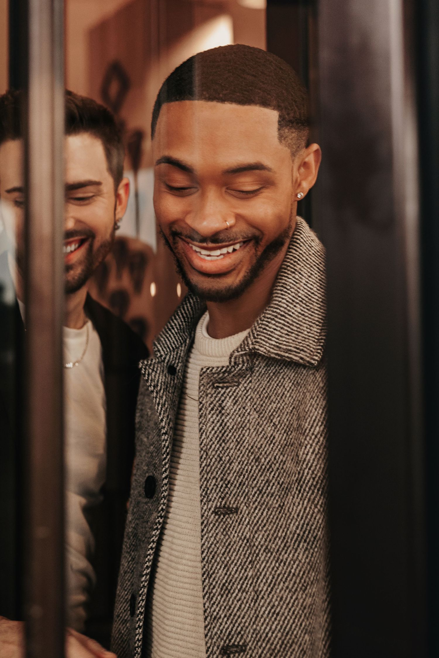 Candid LGBTQ+ engagement portraits in rotating doors at The Westin Huntsville hotel