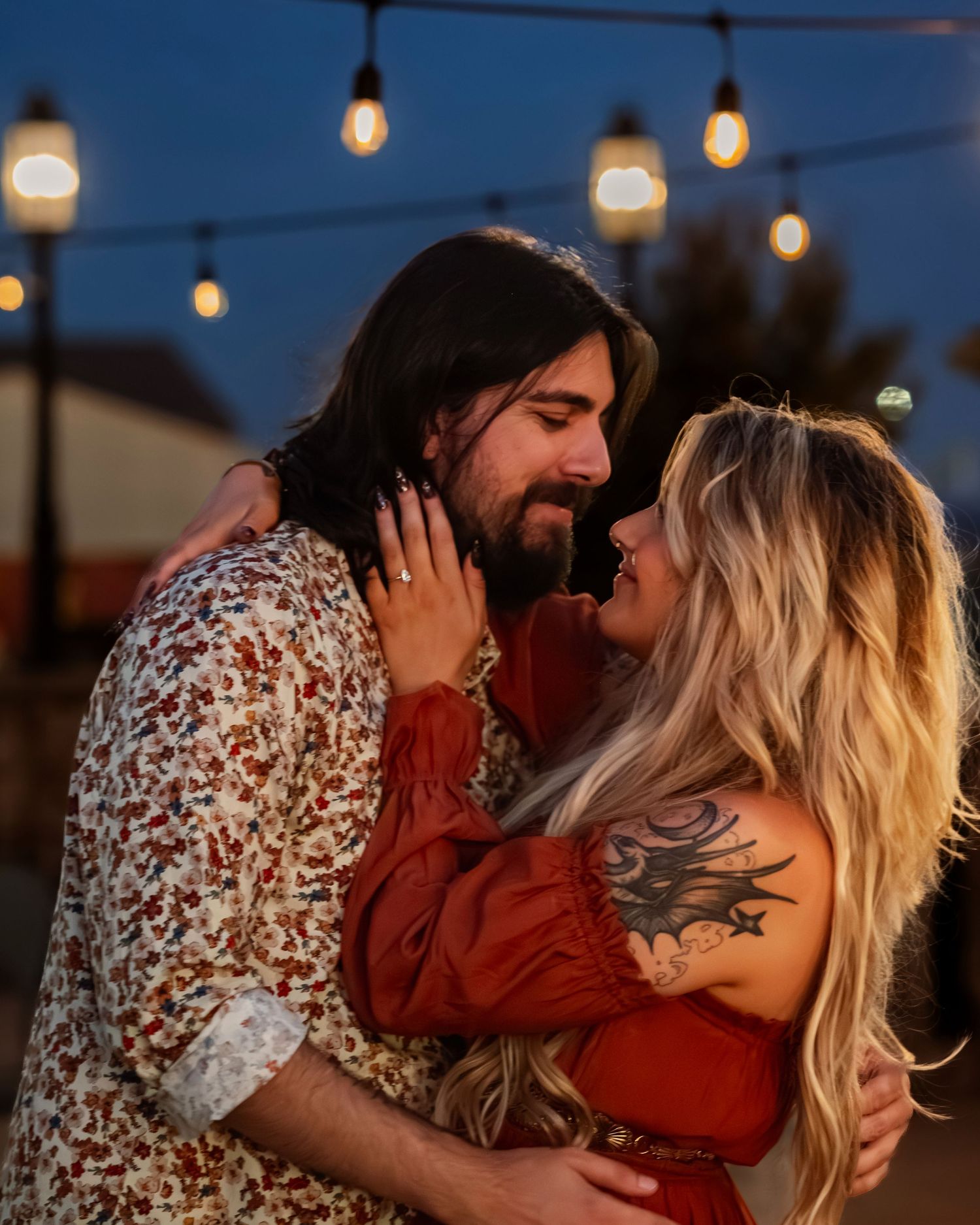 romantic close up portrait of couple staring into each others eyes during blue hour with lights softly glowing behind at Tate Farms