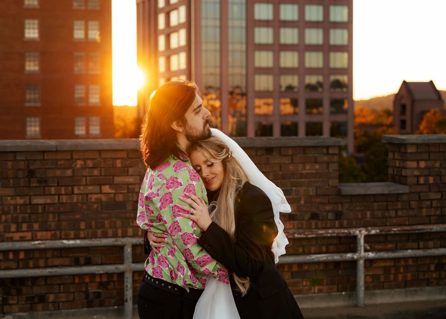 Bride and groom snuggling on a downtown rooftop at sunset in Huntsville, Alabama