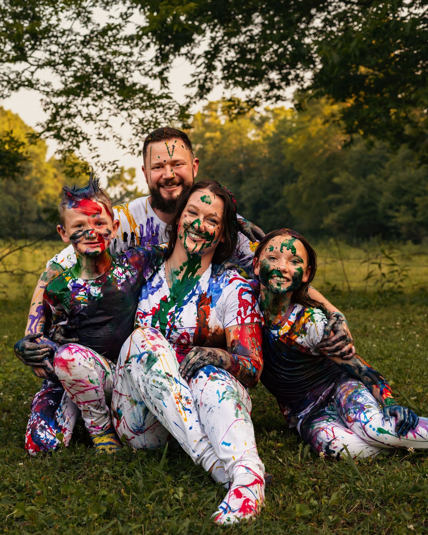 Family after enjoying a colorful paint fight during summer photo session, captured by Catch Your Fire Photography in Huntsville, Alabama.