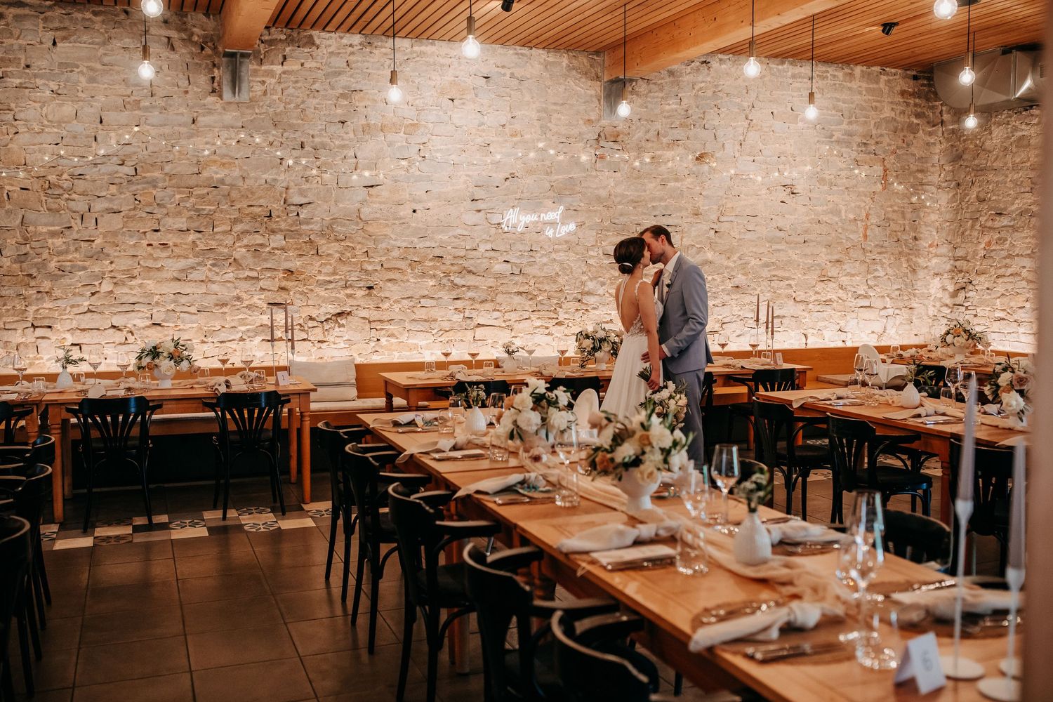 Stilvoll gedeckte Hochzeitstafel in moderner Hochzeitslocation vor dem Eintreffen der Gäste
