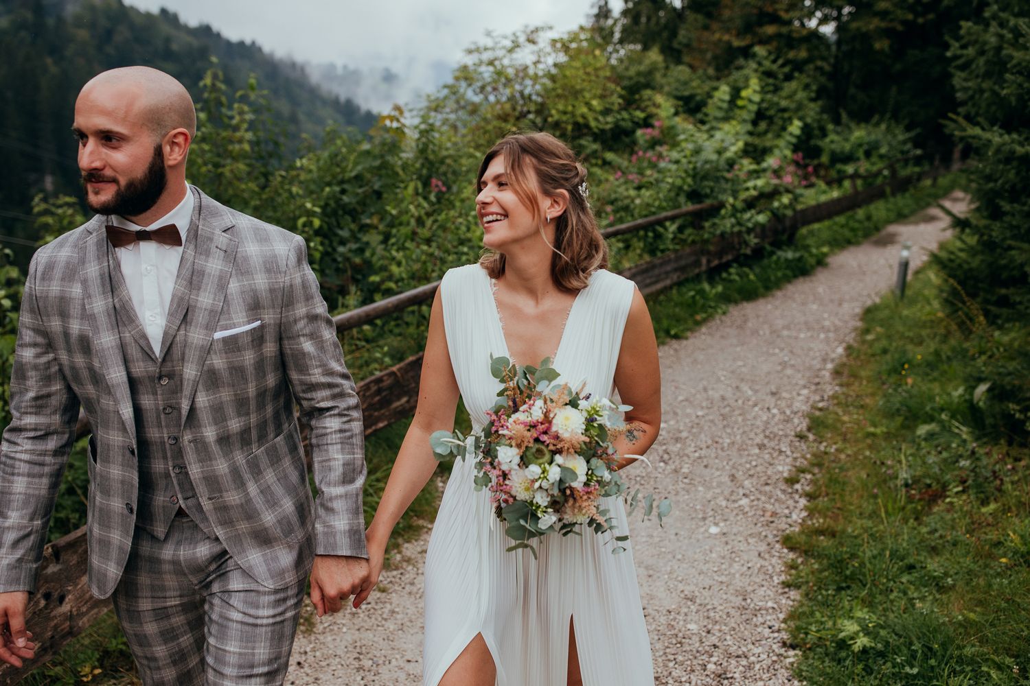 Brautpaar läuft Hand in Hand durch die Natur nach der Trauung in Garmisch