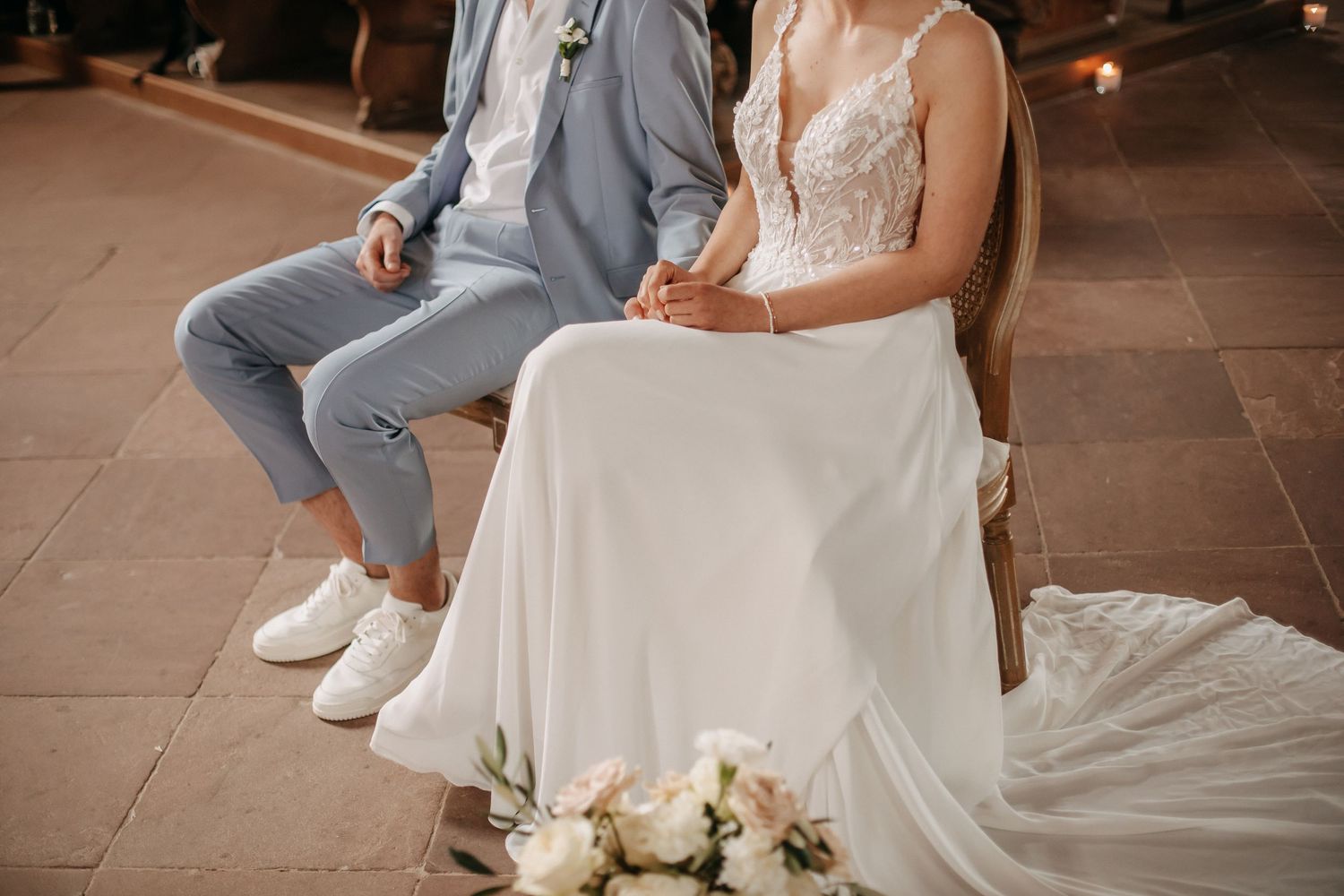 Ruhiger Moment eines Hochzeitspaares im Sitzen mit Blick auf Details bei der kirchlichen Trauung in Bamberg