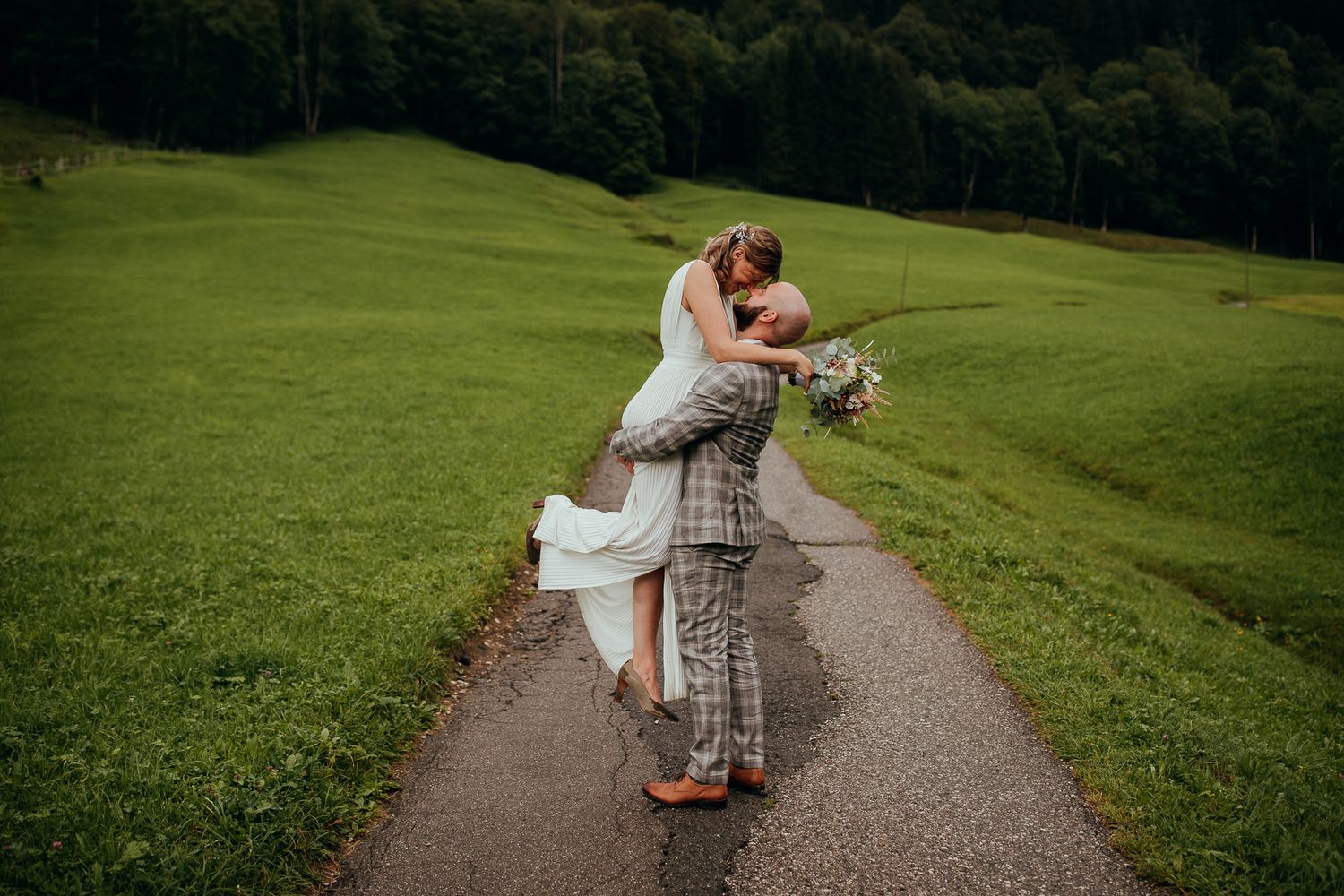 Natürliches Brautpaarfoto auf einem Waldweg bei einer freien Hochzeit im Grünen