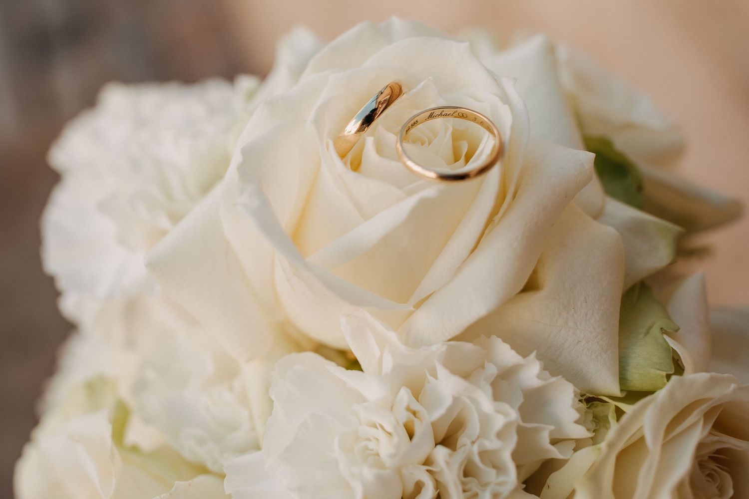 Hochzeitsringe auf Blumenarrangement als ruhiges Detailmotiv