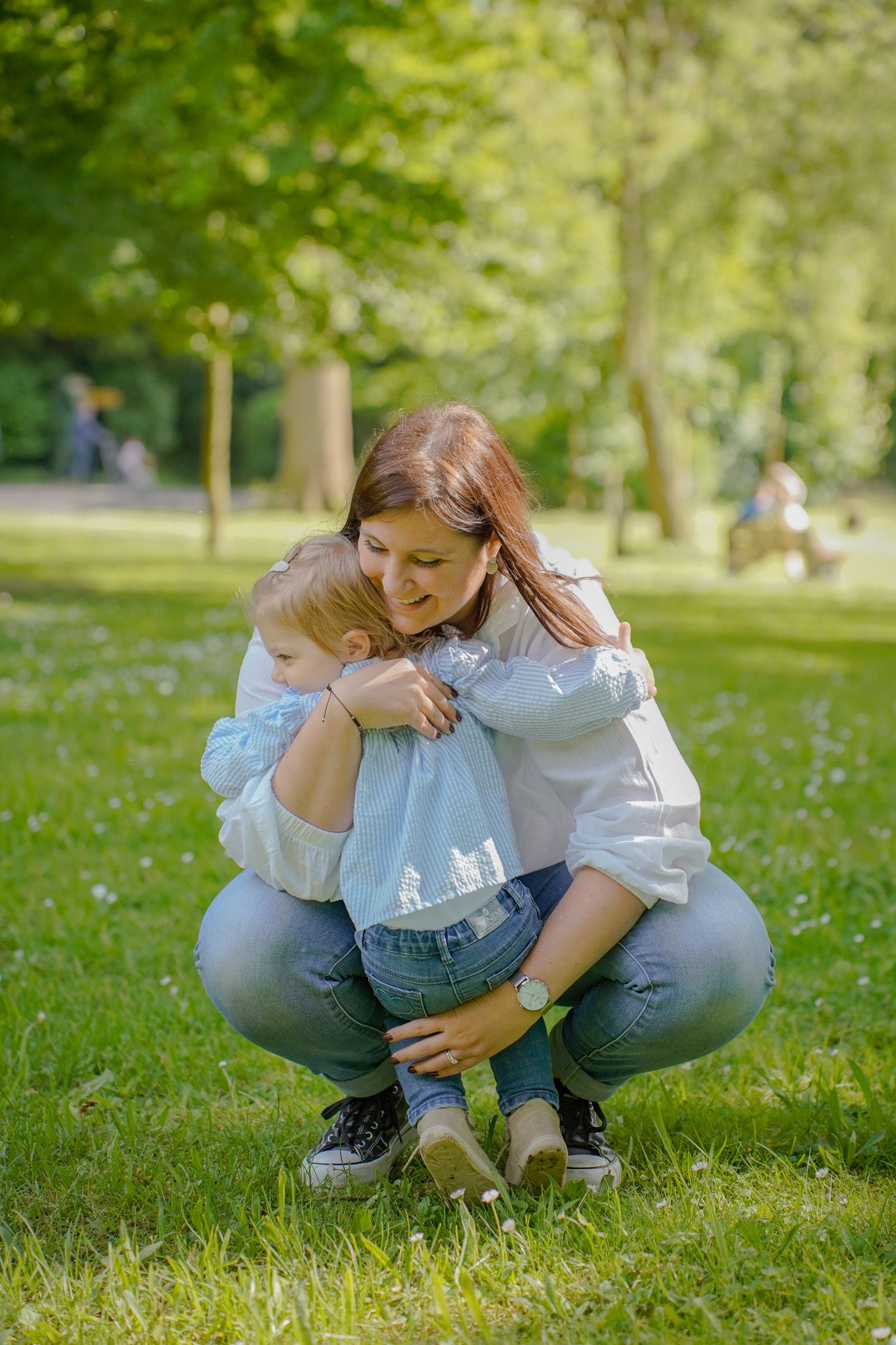 Tender moment captured in a spring park with dandelions and green grass.