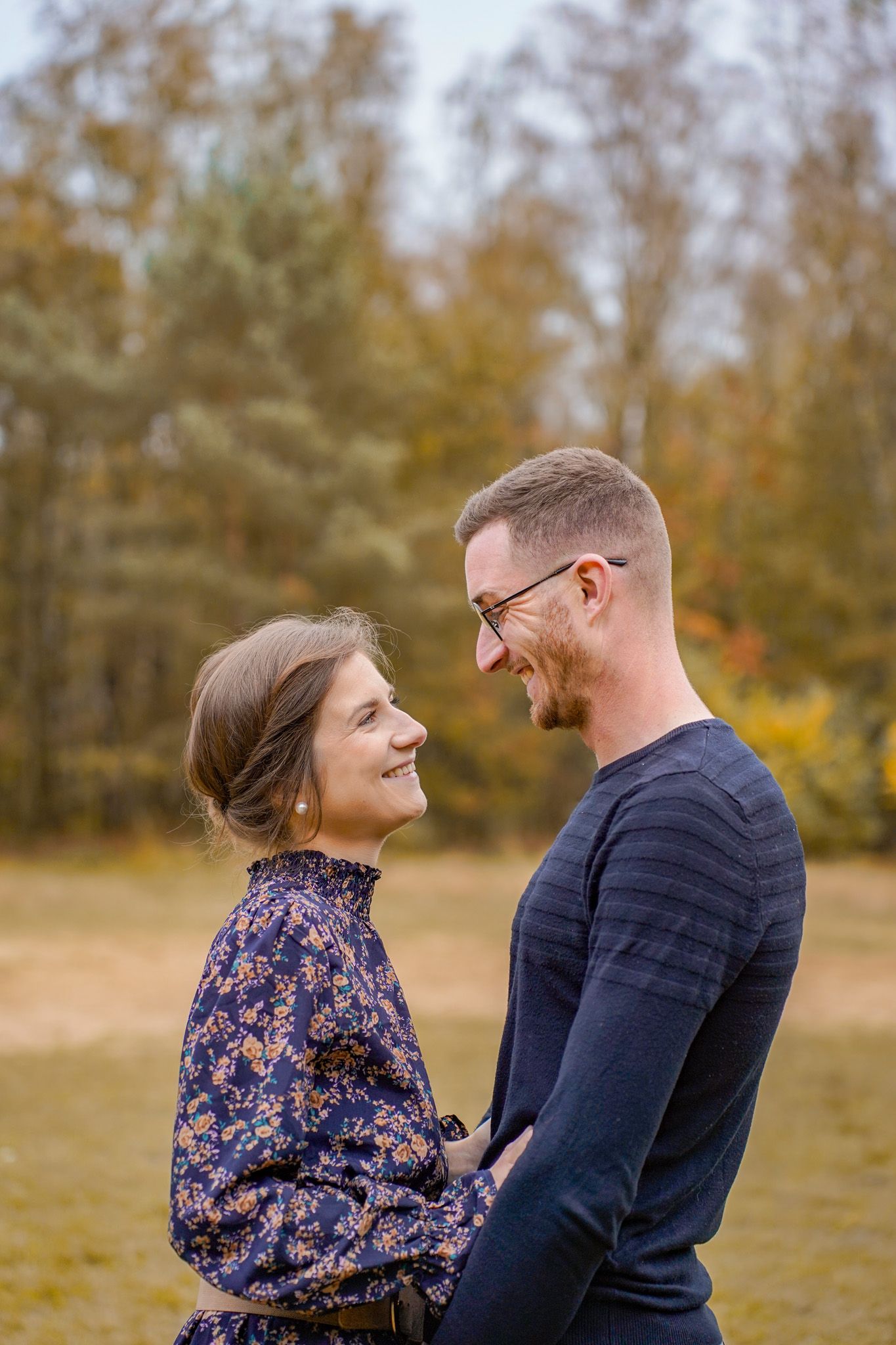 Couple sharing joyful moment together in autumn forest setting.