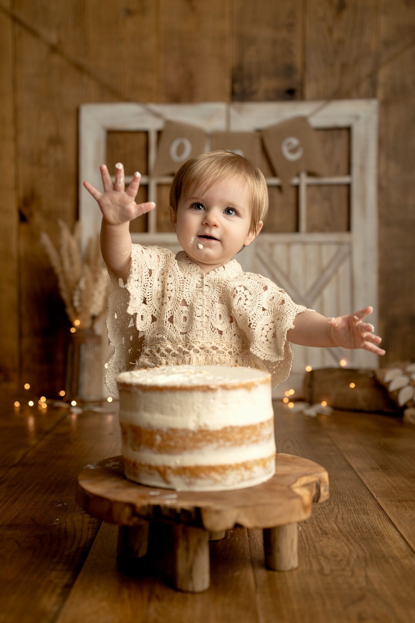 Rustic wooden table with a white frosted cake and warm lighting.