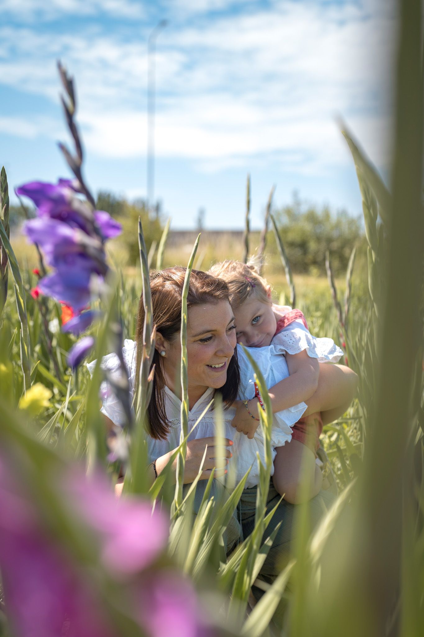 Purple irises frame a tender moment in a spring garden with soft natural lighting.
