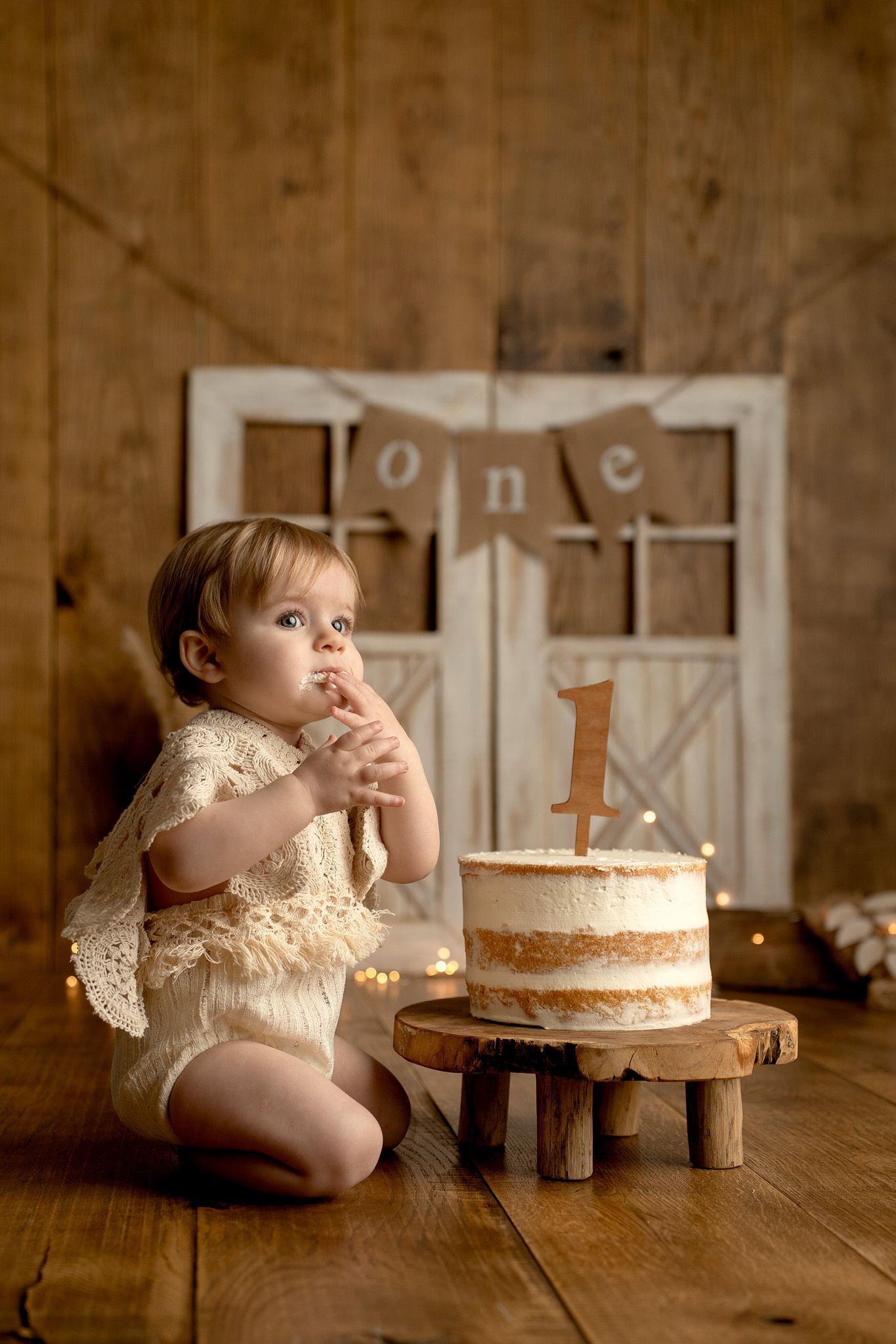 Rustic wooden table setting with cake and number one decoration.