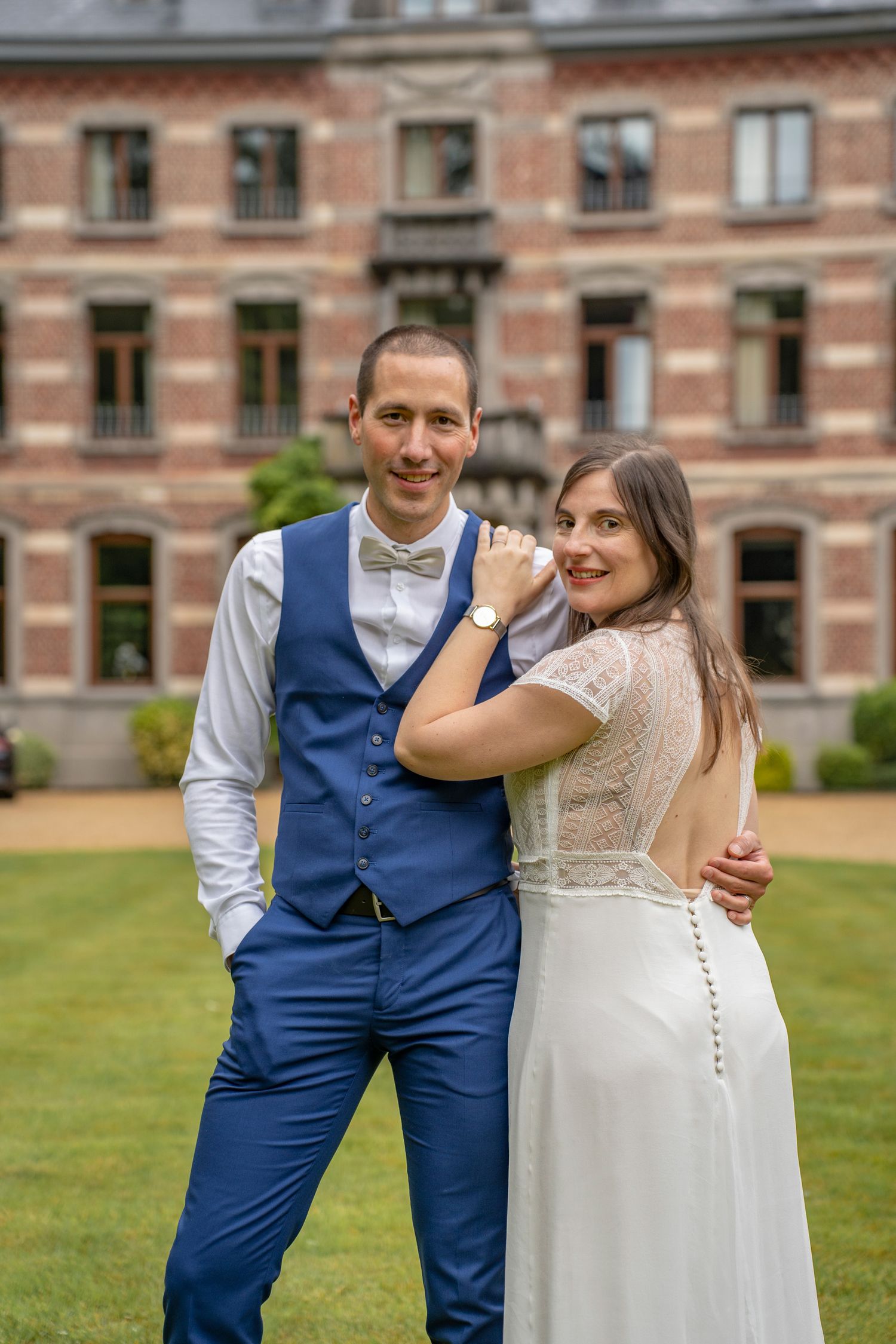 Candid moments between a couple in wedding attire on a manicured lawn.