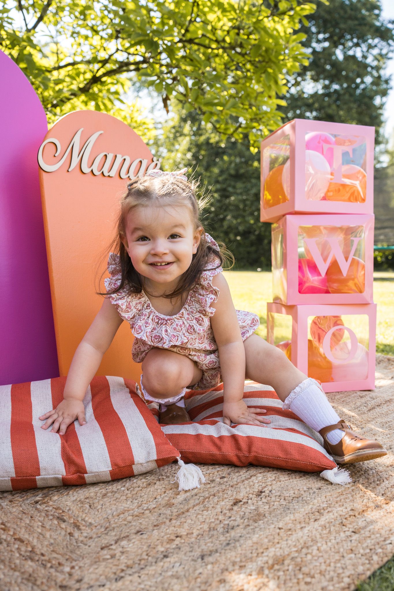 Cheerful outdoor celebration setup with pink boxes and decorative elements on natural ground.