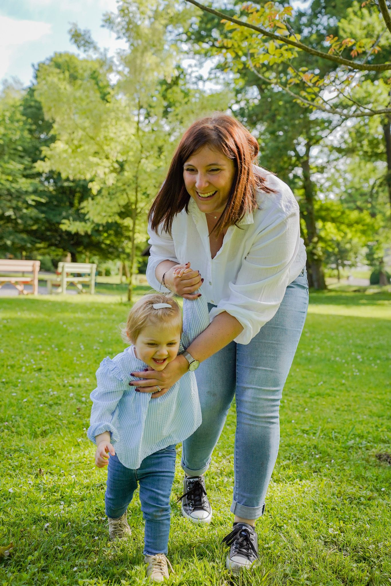 Playful moments shared on green grass in a sunny park setting.