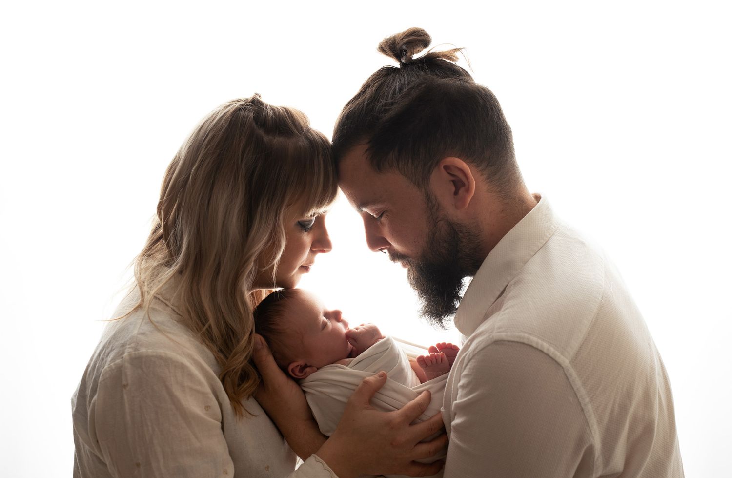 Intimate silhouette portrait of couple against white background.