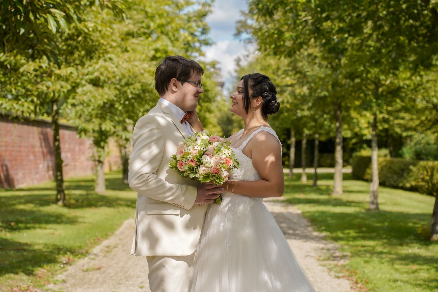 Romantic wedding portraits captured in a sunlit garden path.