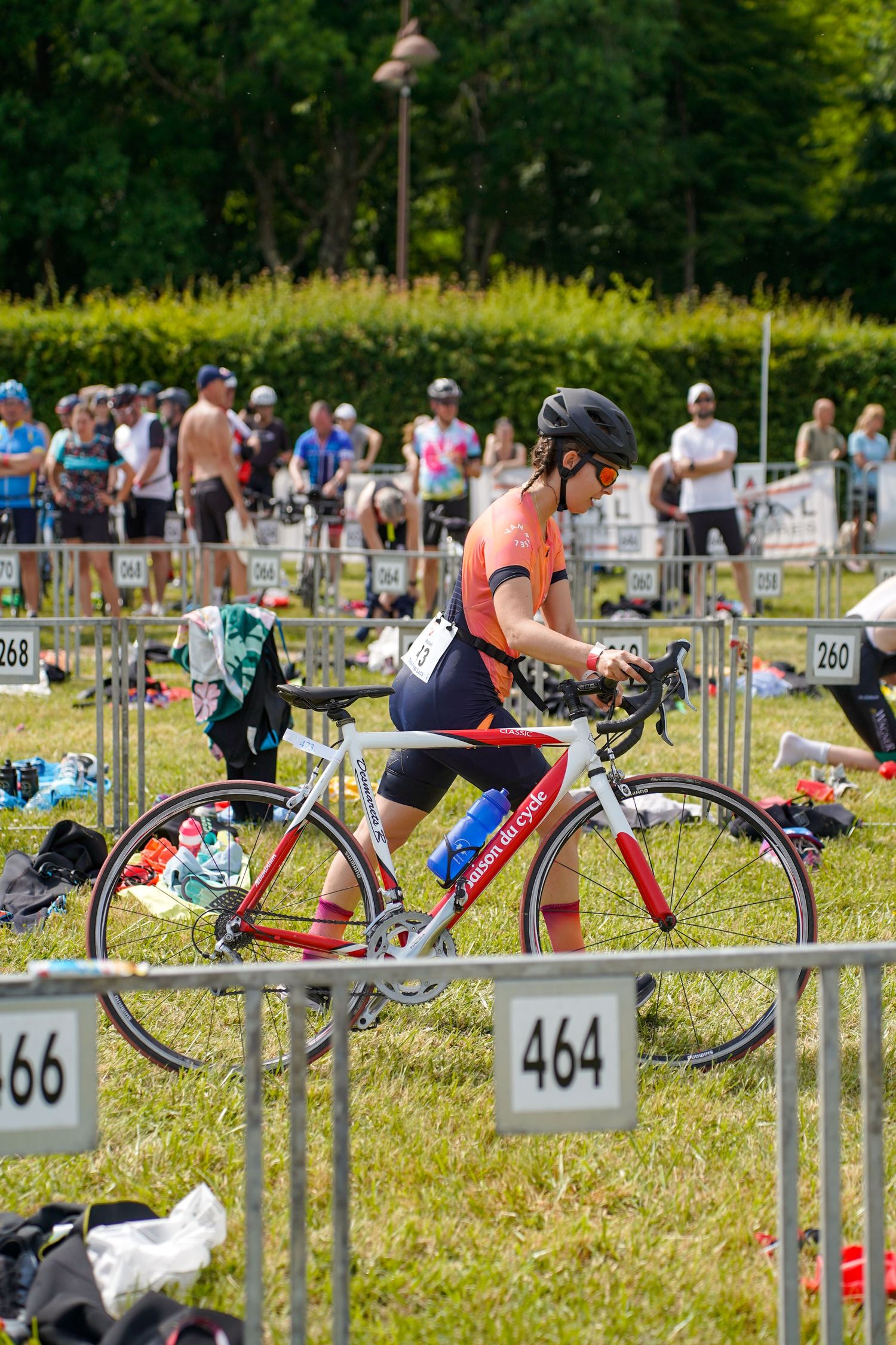 Triathlon bikes lined up in transition zone with numbered racks.