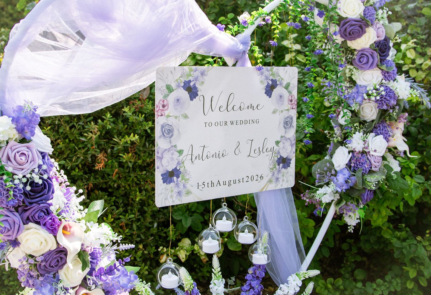 Purple and white floral wedding welcome sign for Antonio and Lesley, dated 25th August 2024.