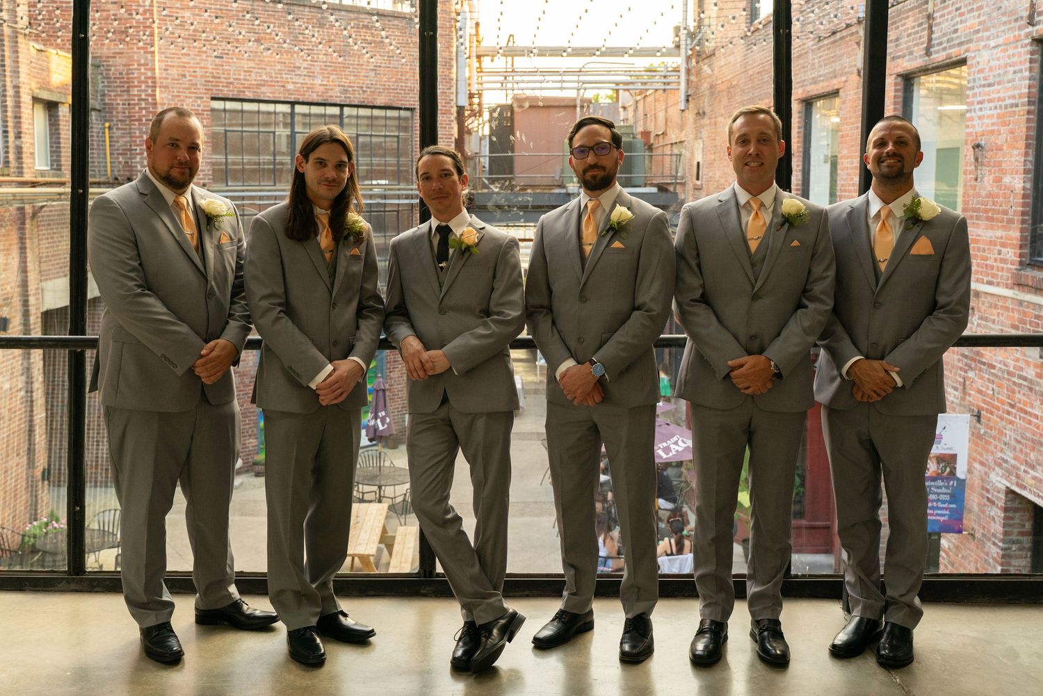 Wedding party poses in front of a tall window