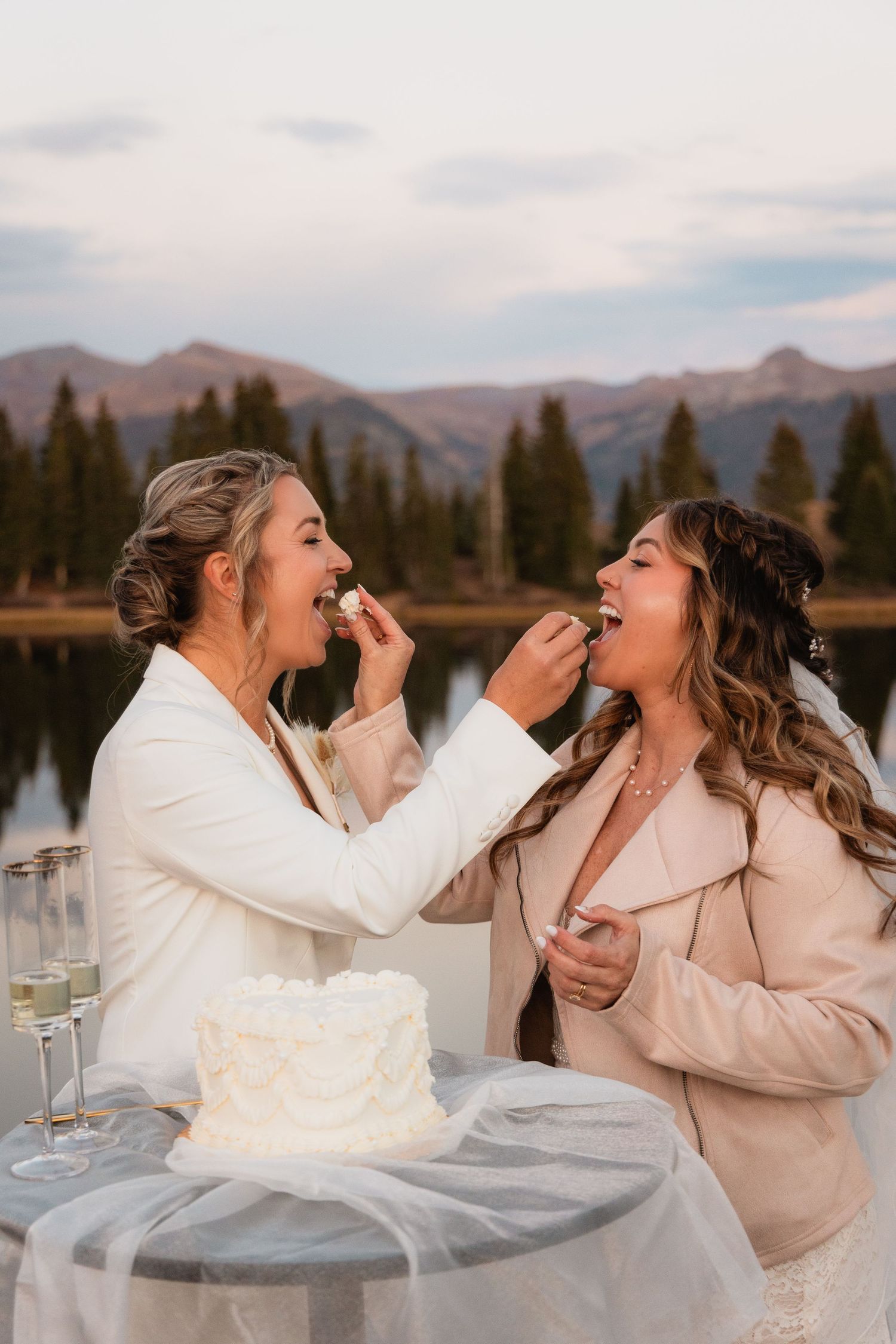 Playful cake feeding moment at outdoor mountain colorado elopement