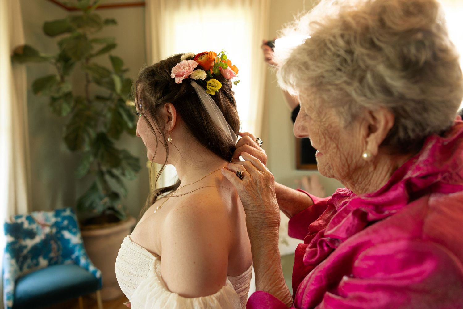 Emotional wedding moment captured between attendees in a venue with natural lighting.