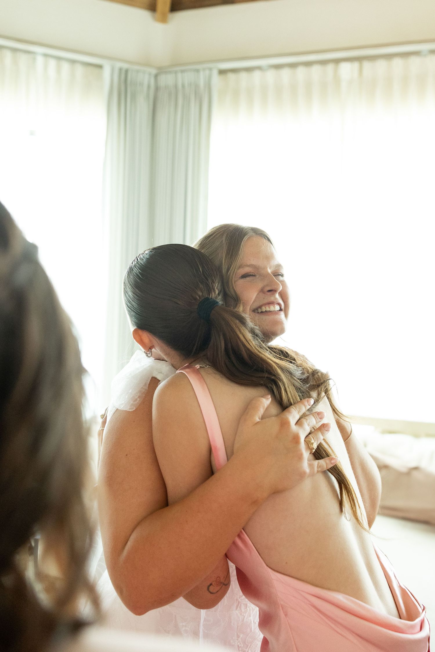 A joyful moment captured as two people share an emotional embrace in a bright room.
