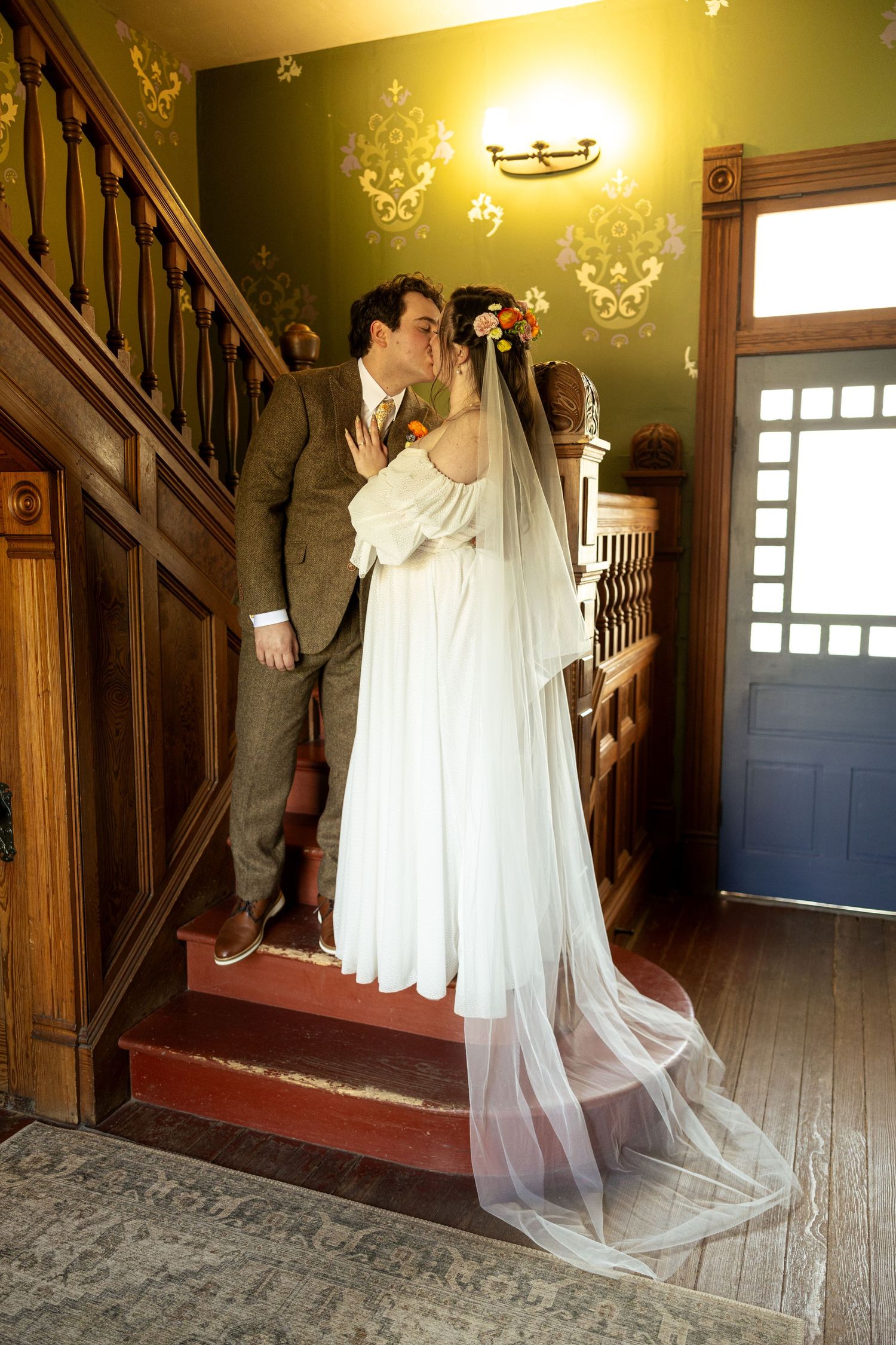 A romantic wedding scene unfolds in a vintage hallway with wooden details.