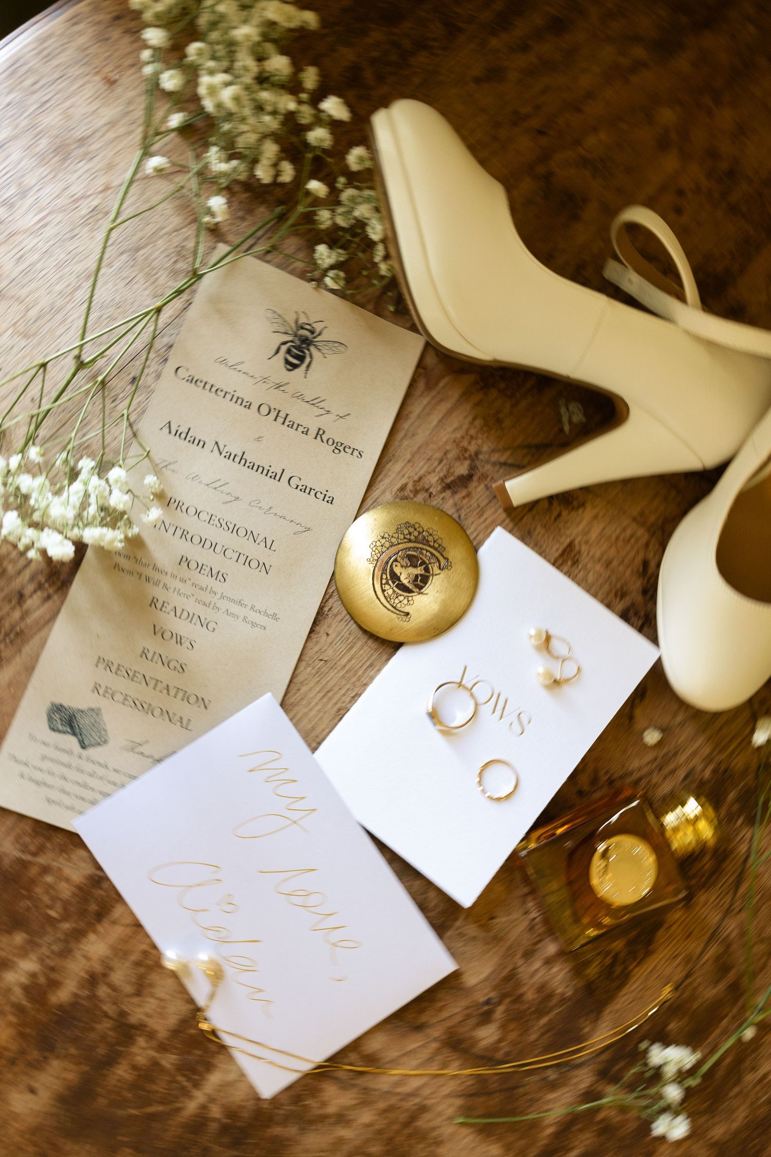 Wedding invitation with elegant calligraphy and floral details on a rustic wooden surface.
