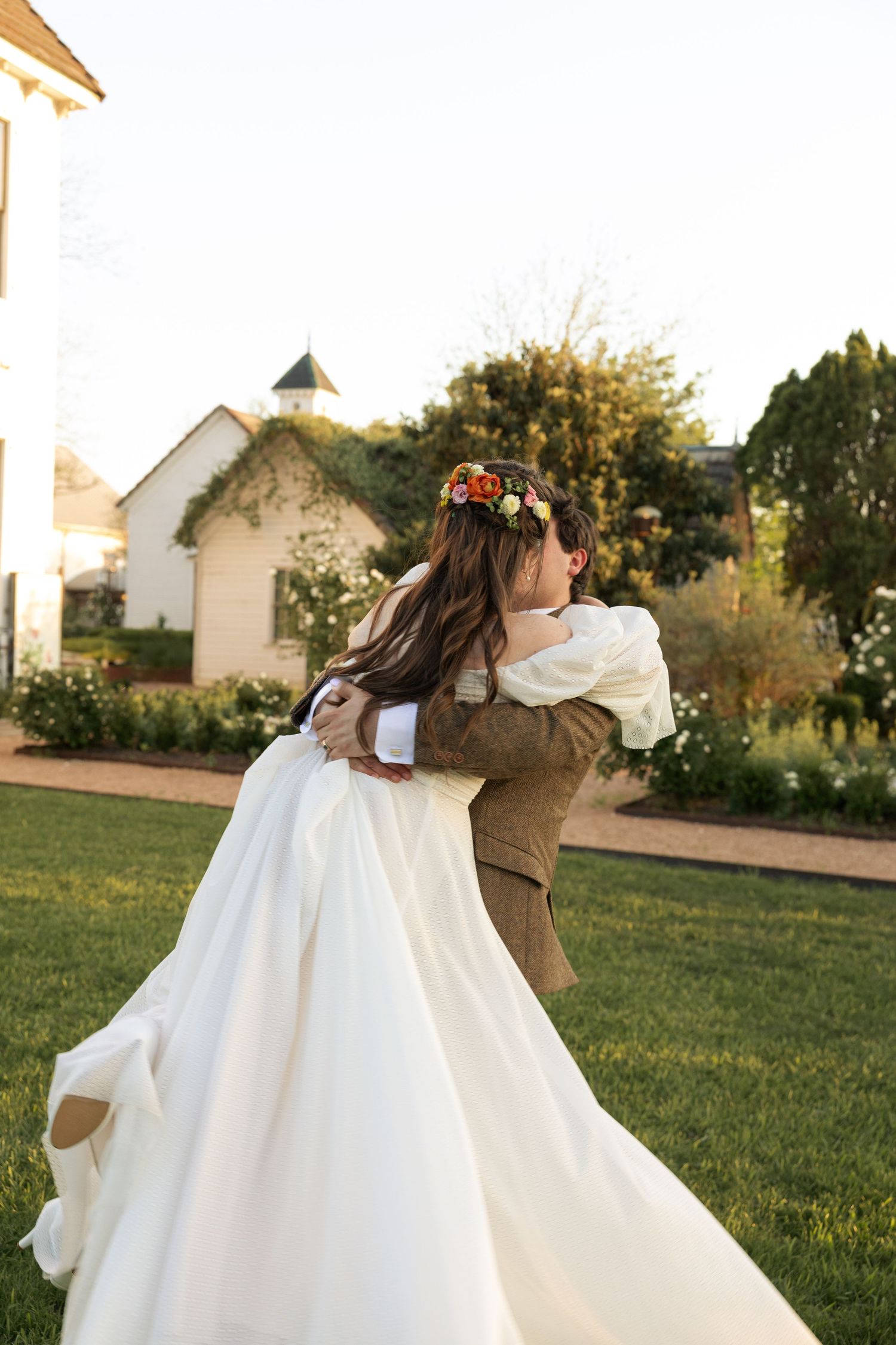 A romantic spin captured during a sunset wedding celebration on a manicured lawn.