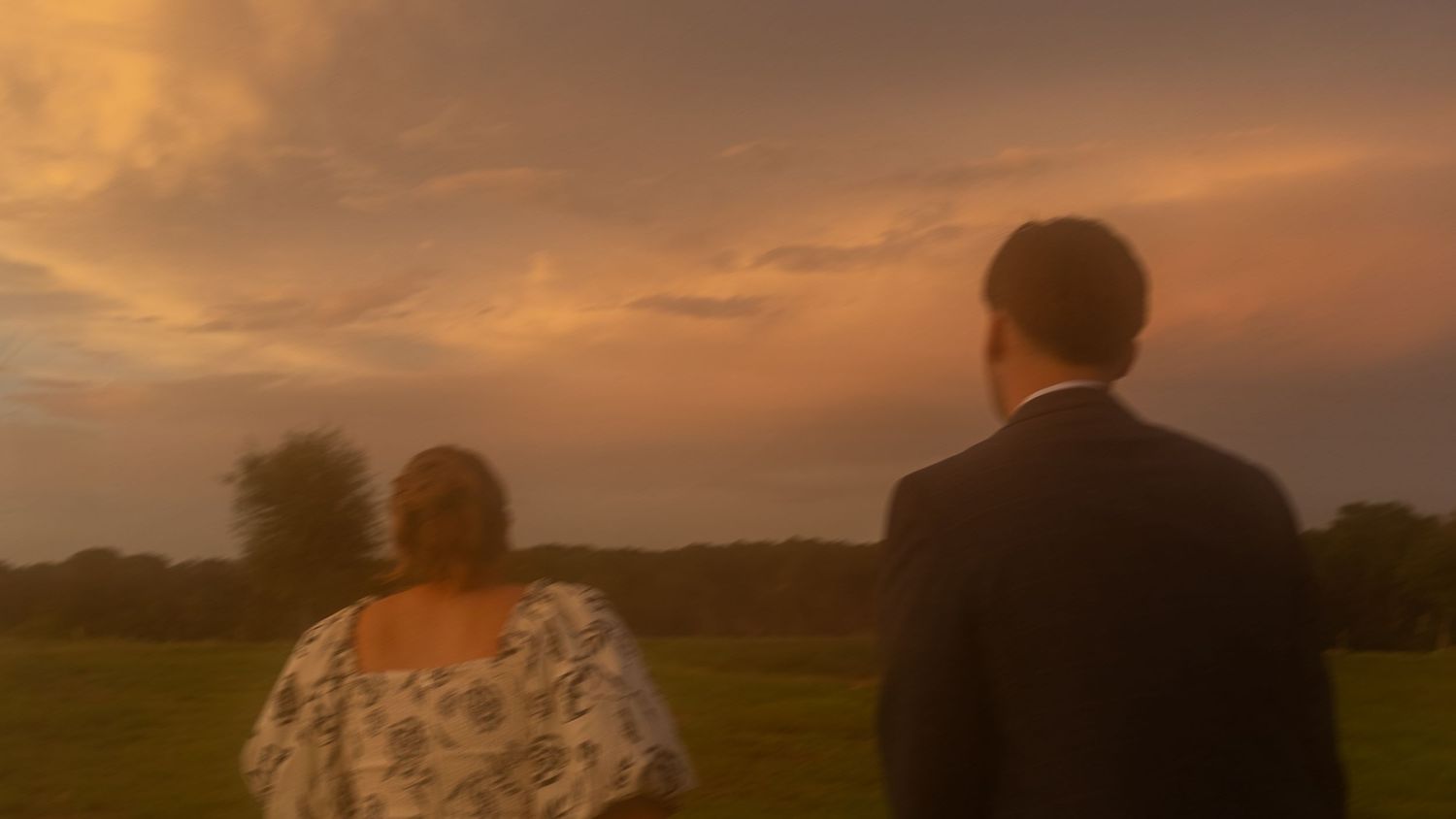 Stunning golden sunset sky creates dramatic backdrop for outdoor wedding photography.