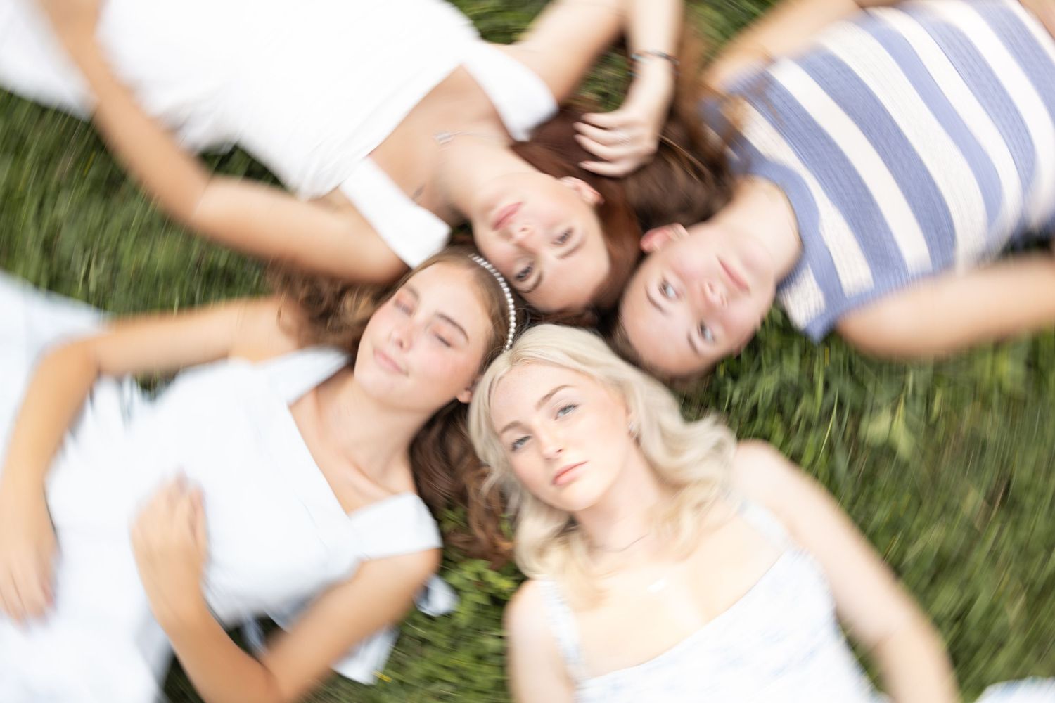 People relaxing together lying in grass during outdoor photoshoot.