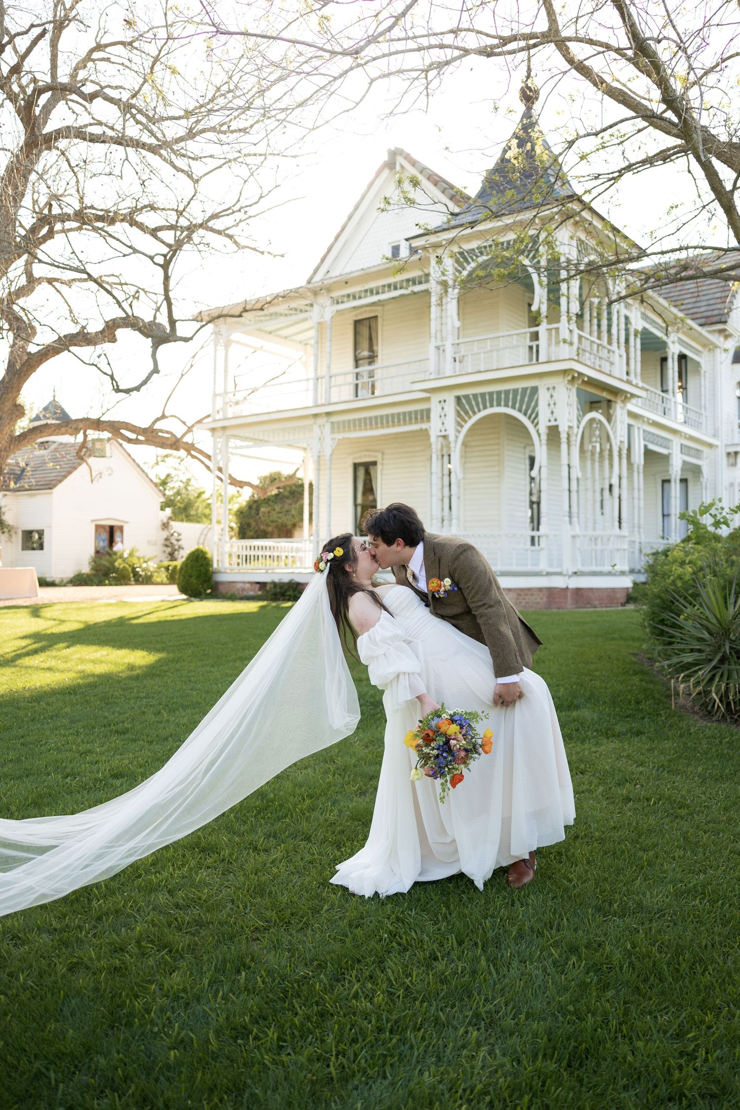 Romantic wedding portraits on a lawn with Victorian houses in the background.