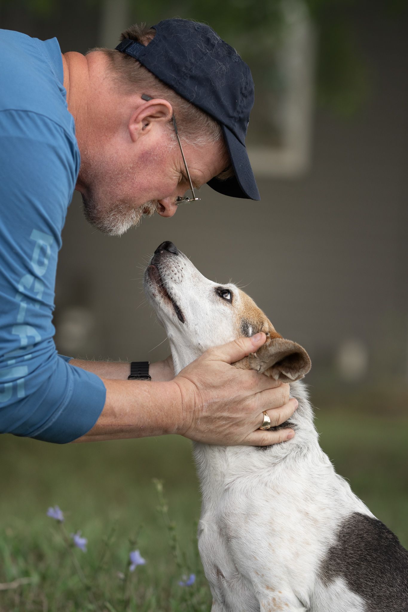 Heartwarming interaction between a person and their white dog sharing affectionate moments outdoors.