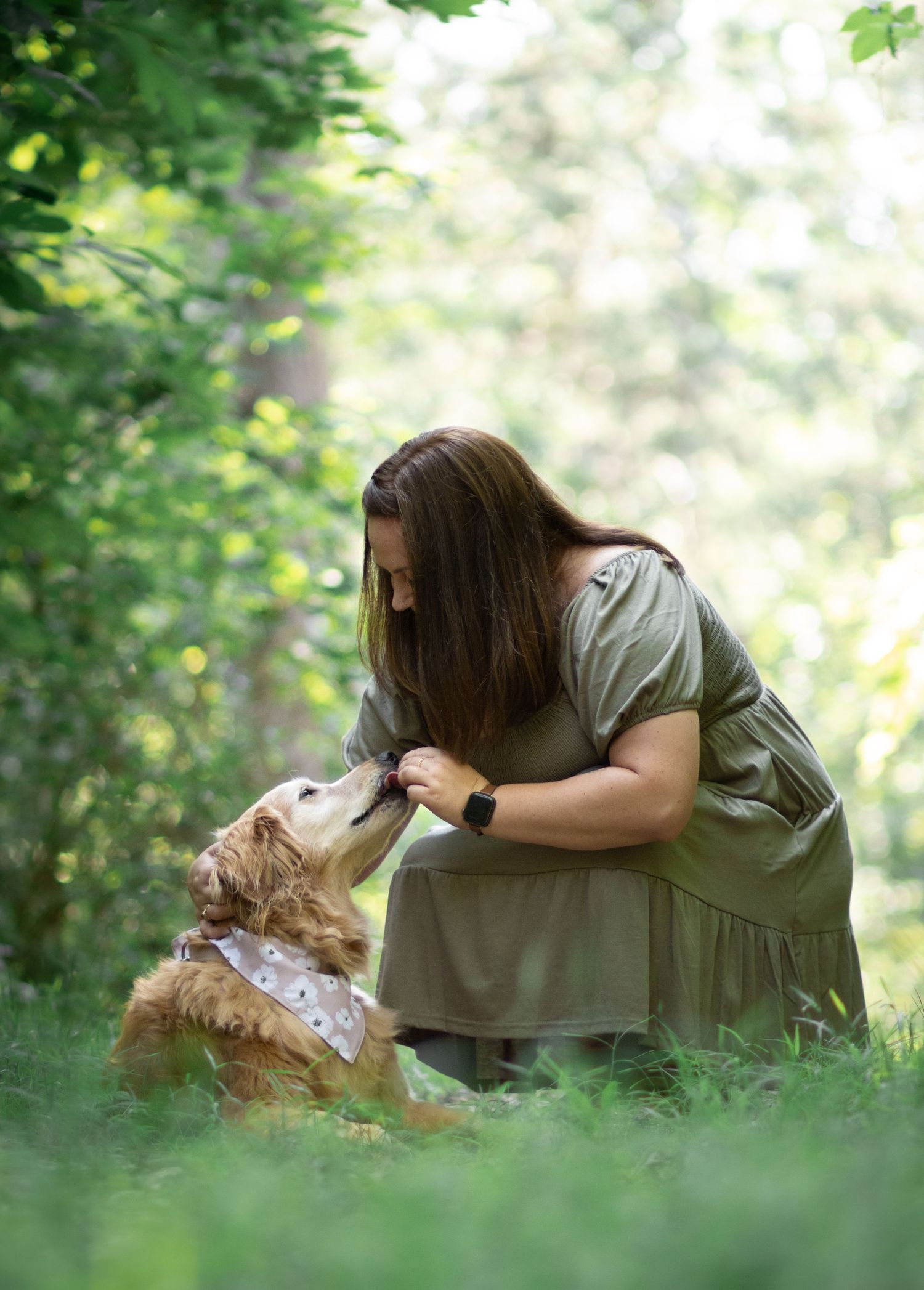 Sweet moment between person and dog in lush green garden setting.