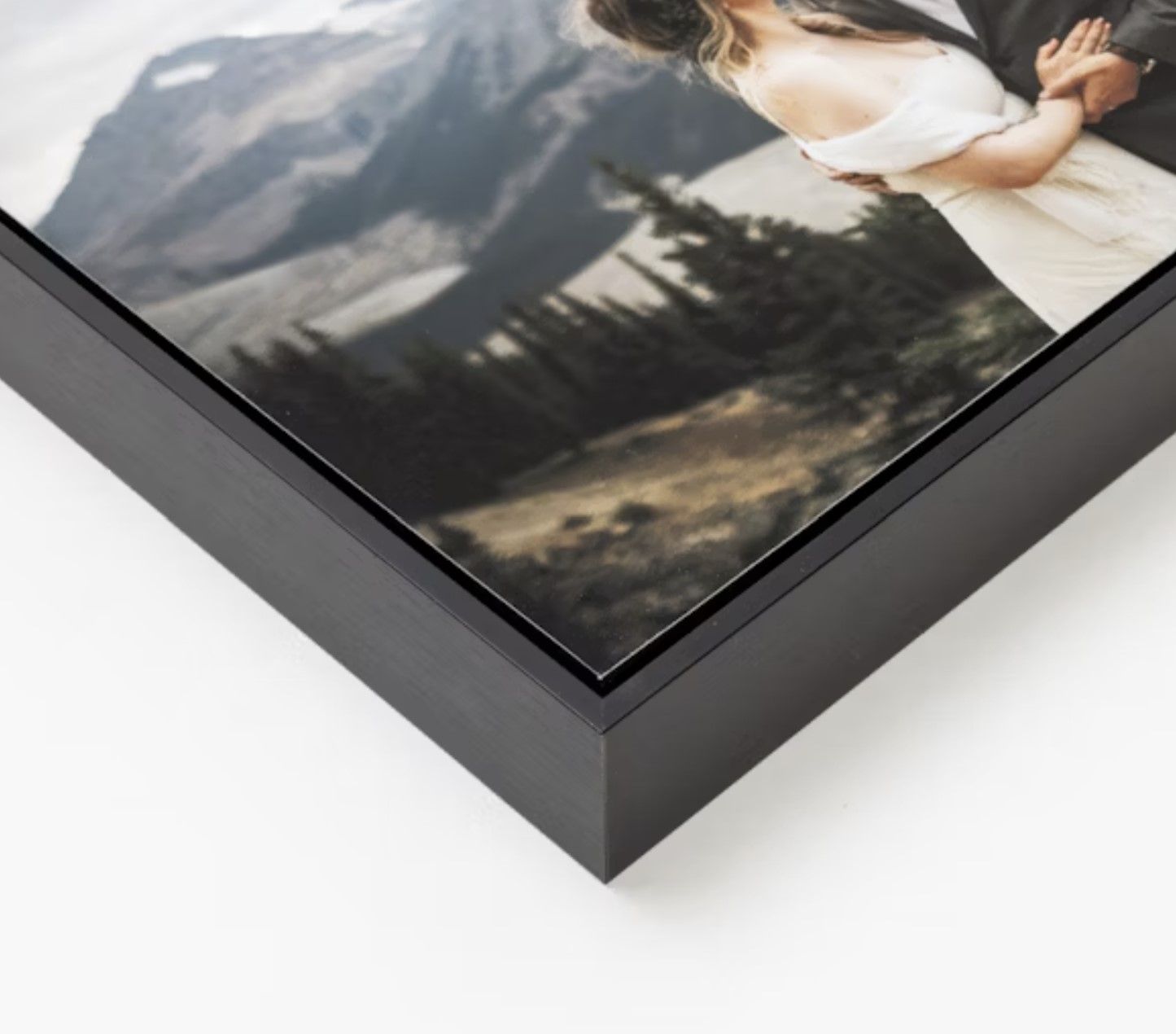 Close-up detail of a black picture frame corner showing professional mounting and finish.