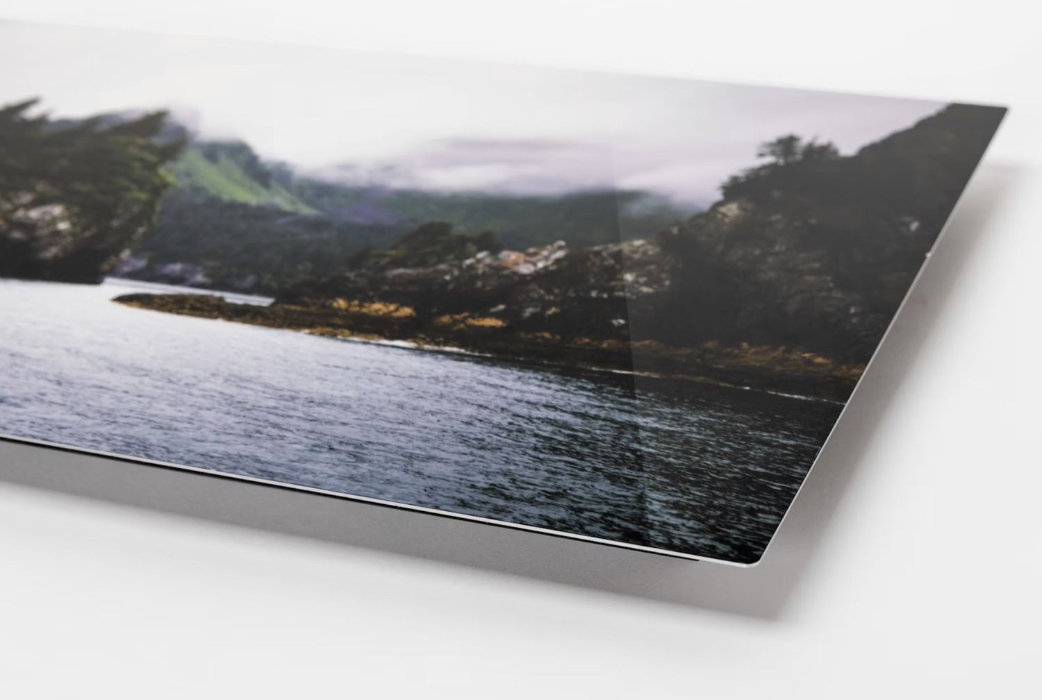 Coastal landscape photograph printed on metallic paper showing water and shoreline.
