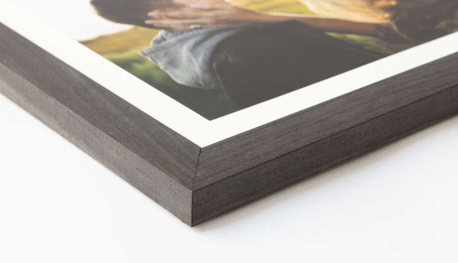 Close-up detail of a black picture frame corner showing professional construction.