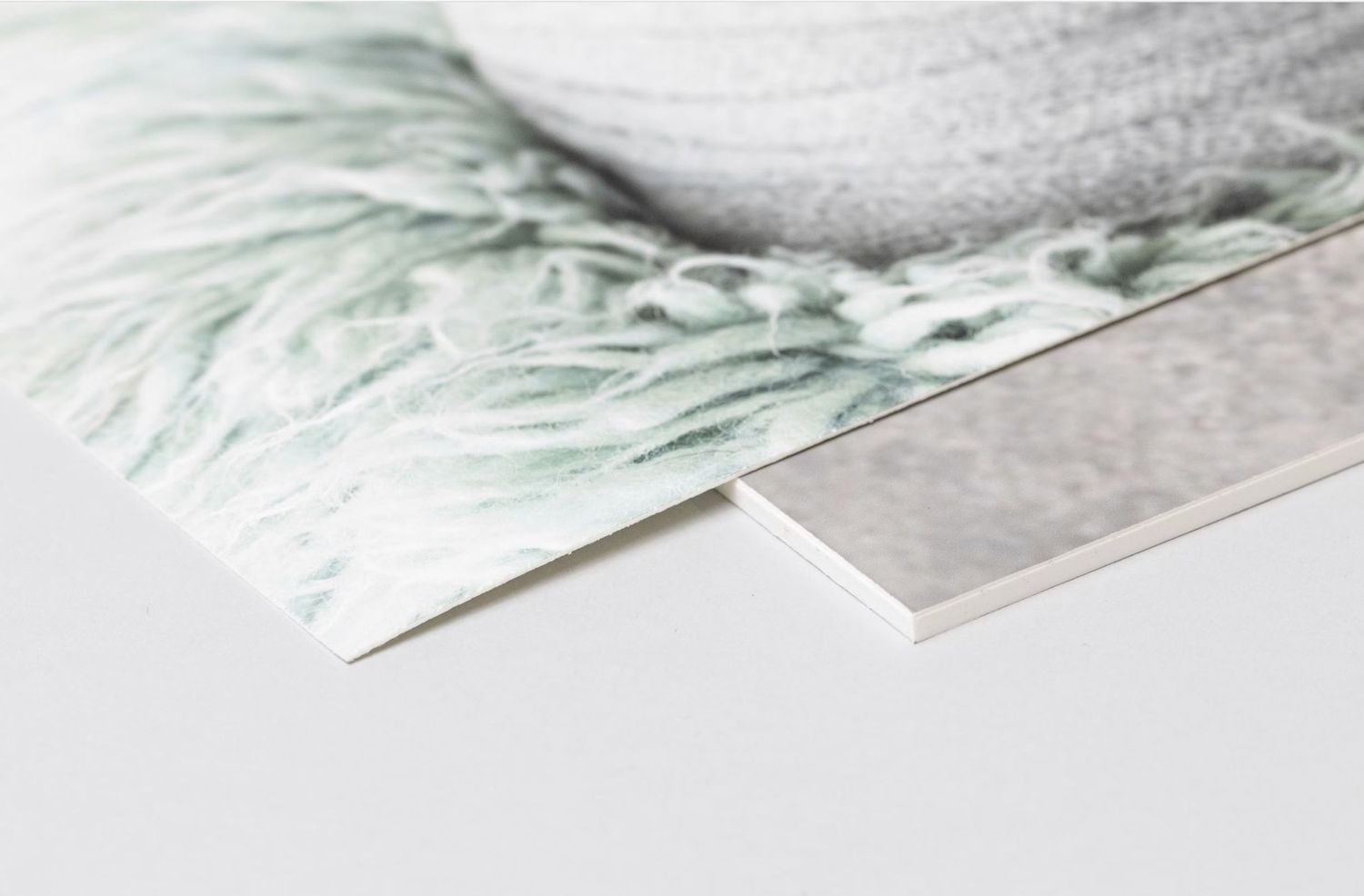 Close-up of photo print edges showing textured paper quality and layered materials.
