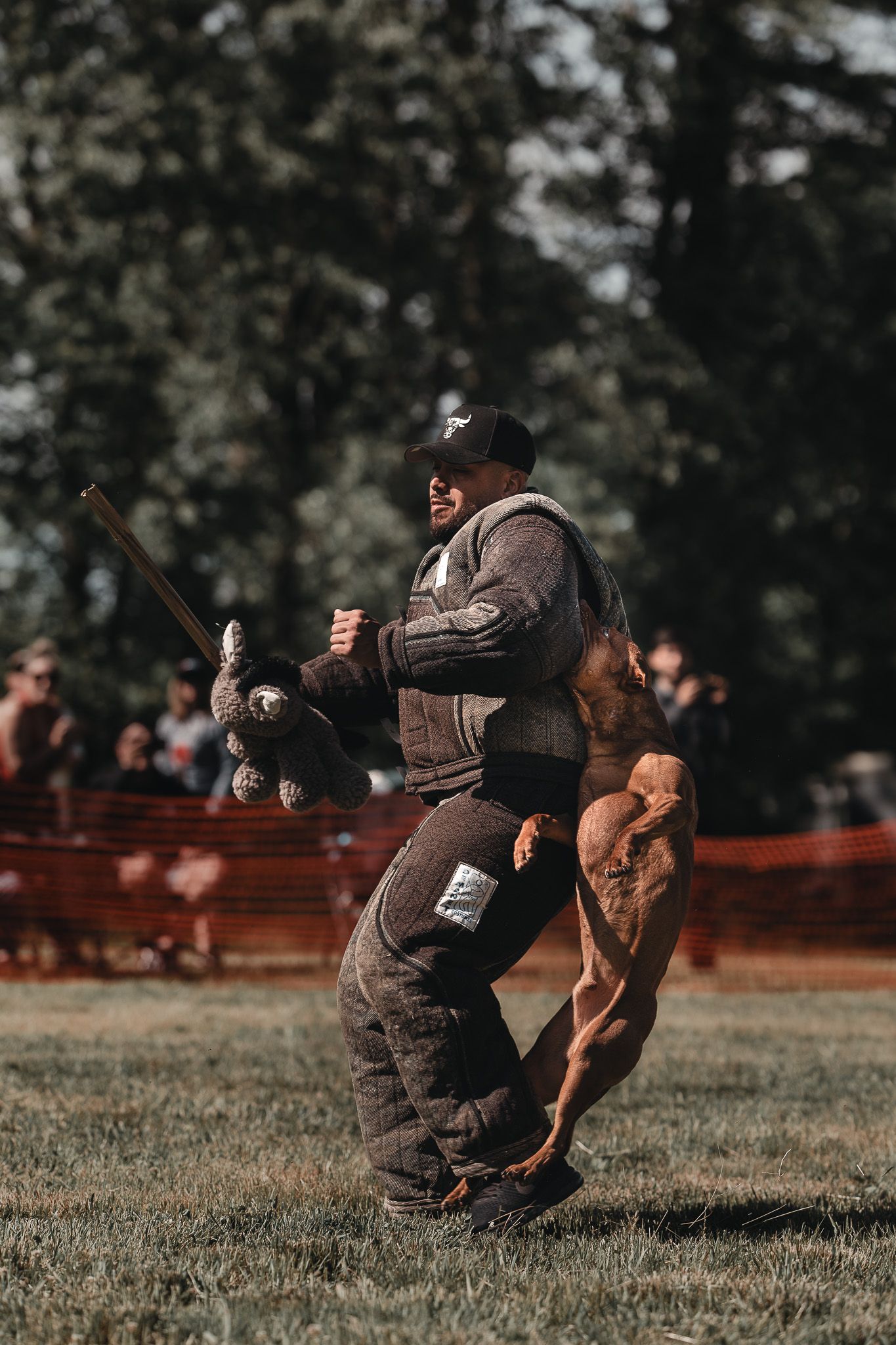 Muscular strongman competitor swinging a heavy mace at an outdoor strength competition on grass.