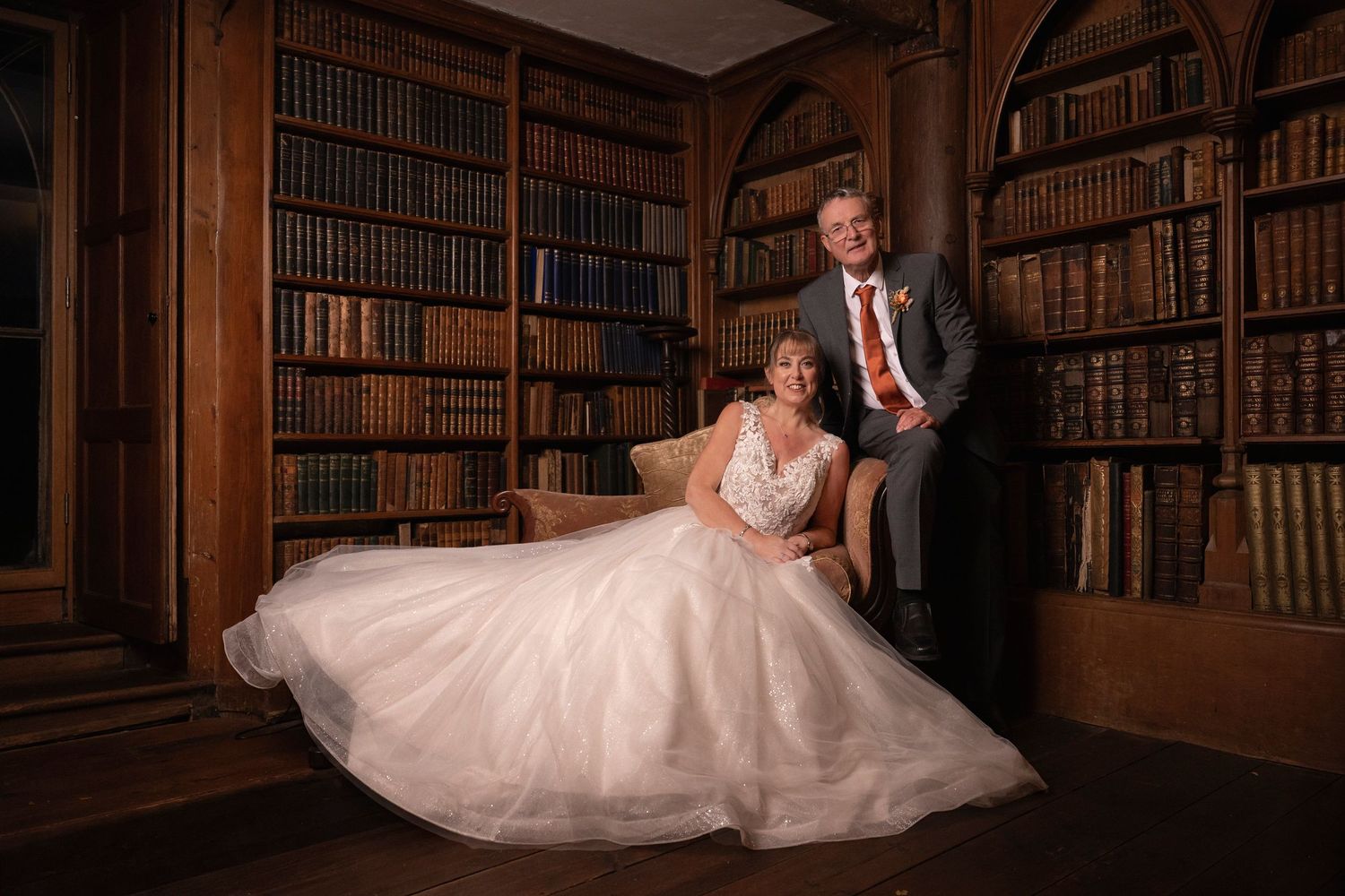 A romantic wedding photo series captured in an elegant library with bookshelves and warm lighting.
