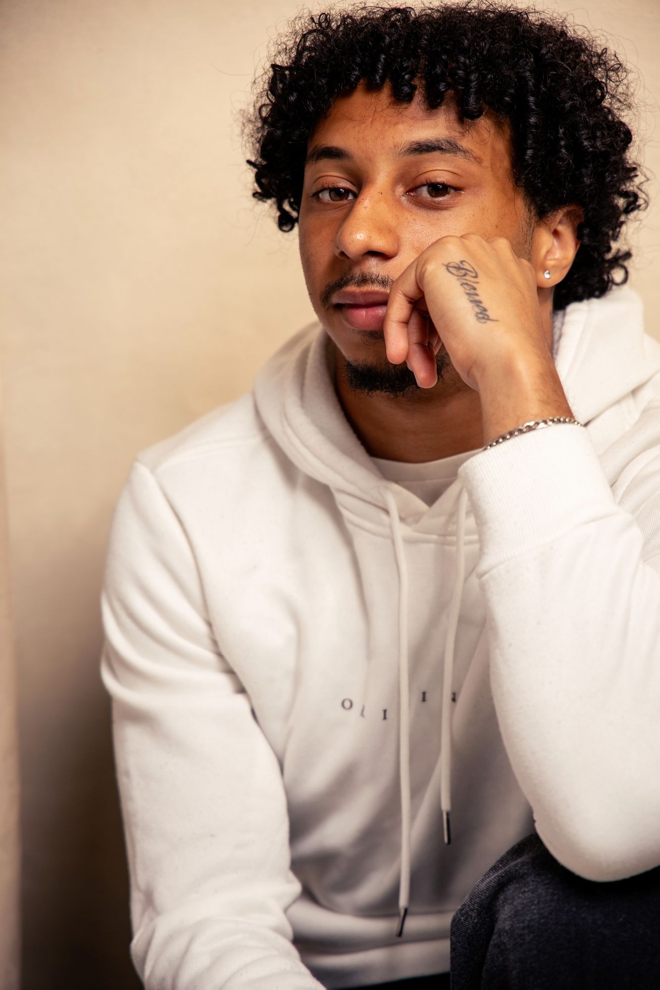 Modern portrait series featuring white hoodie and natural curly hair.