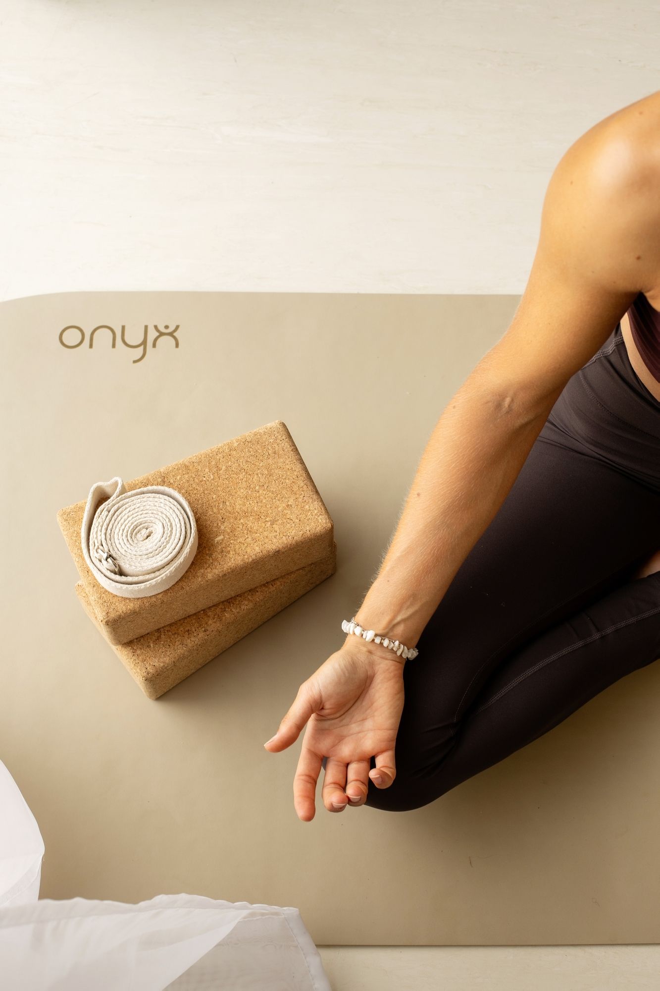 Minimalist yoga setup with cork accessories against neutral background.