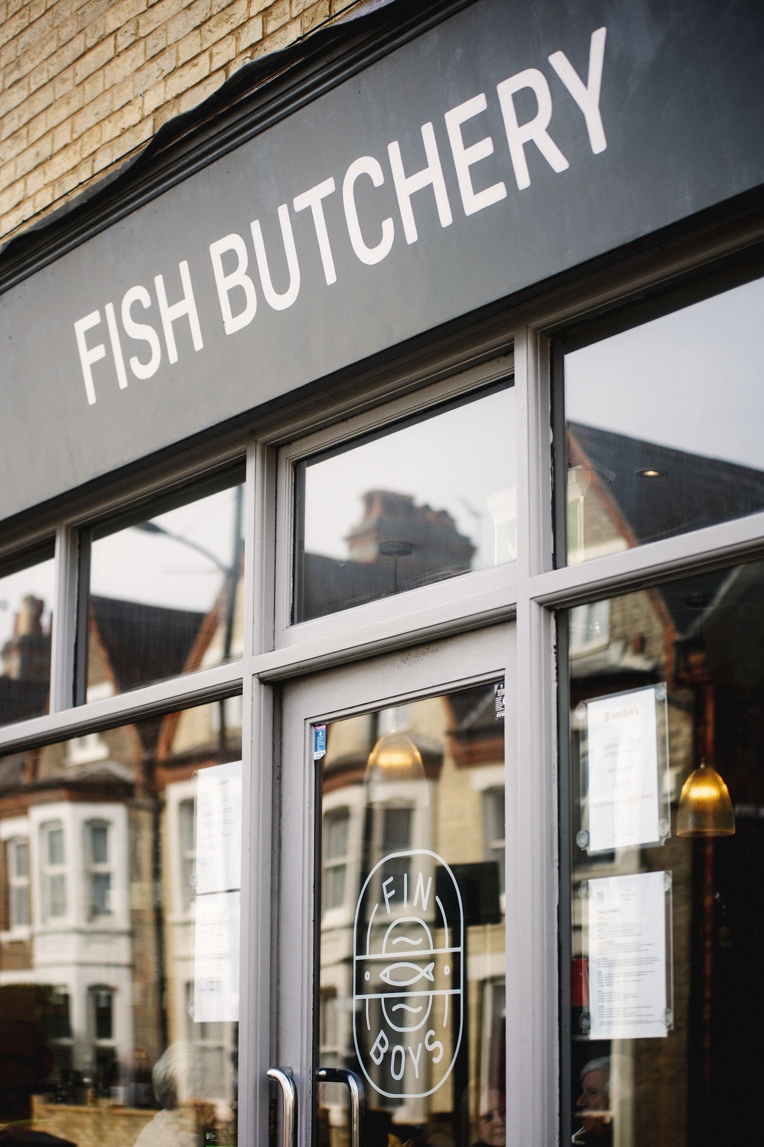 A storefront window displays 'FISH BUTCHERY' text in white letters against a dark background.