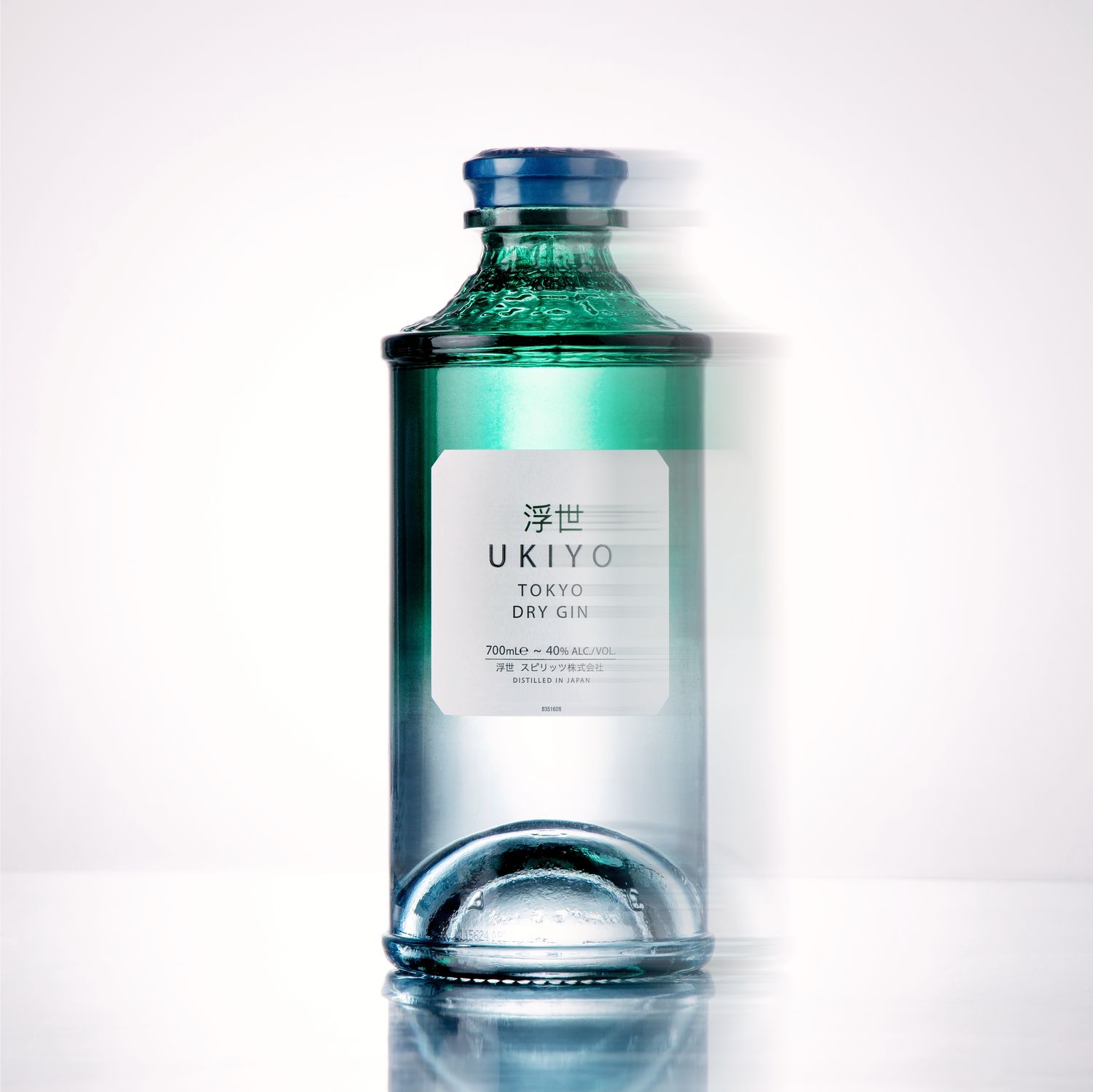 A translucent teal glass bottle with a white label against a light background, showcasing elegant minimalist design.