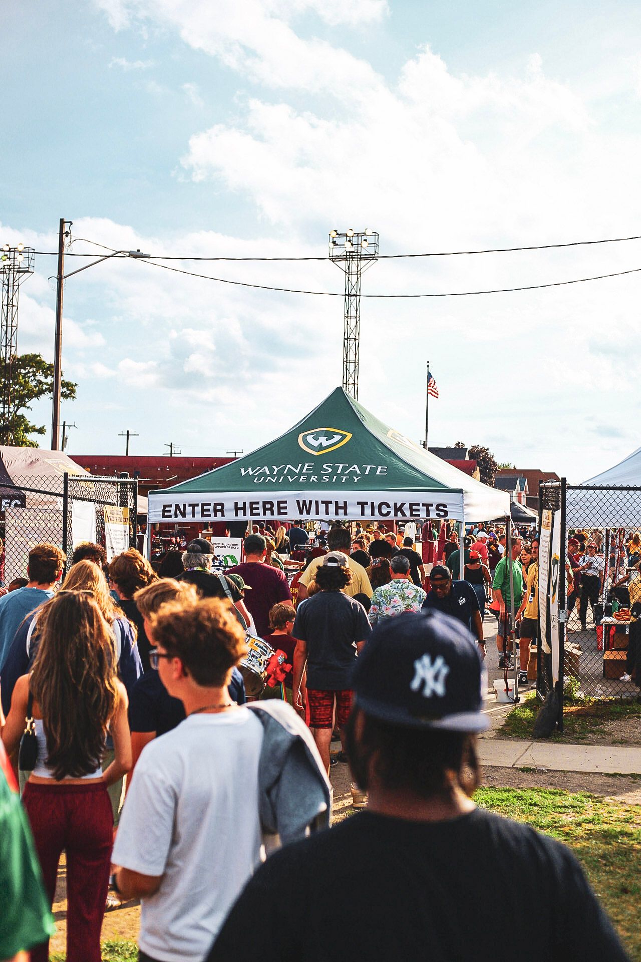 Crowd of fans entering a Detroit City FC soccer match through a Wayne State University ticketed gate.