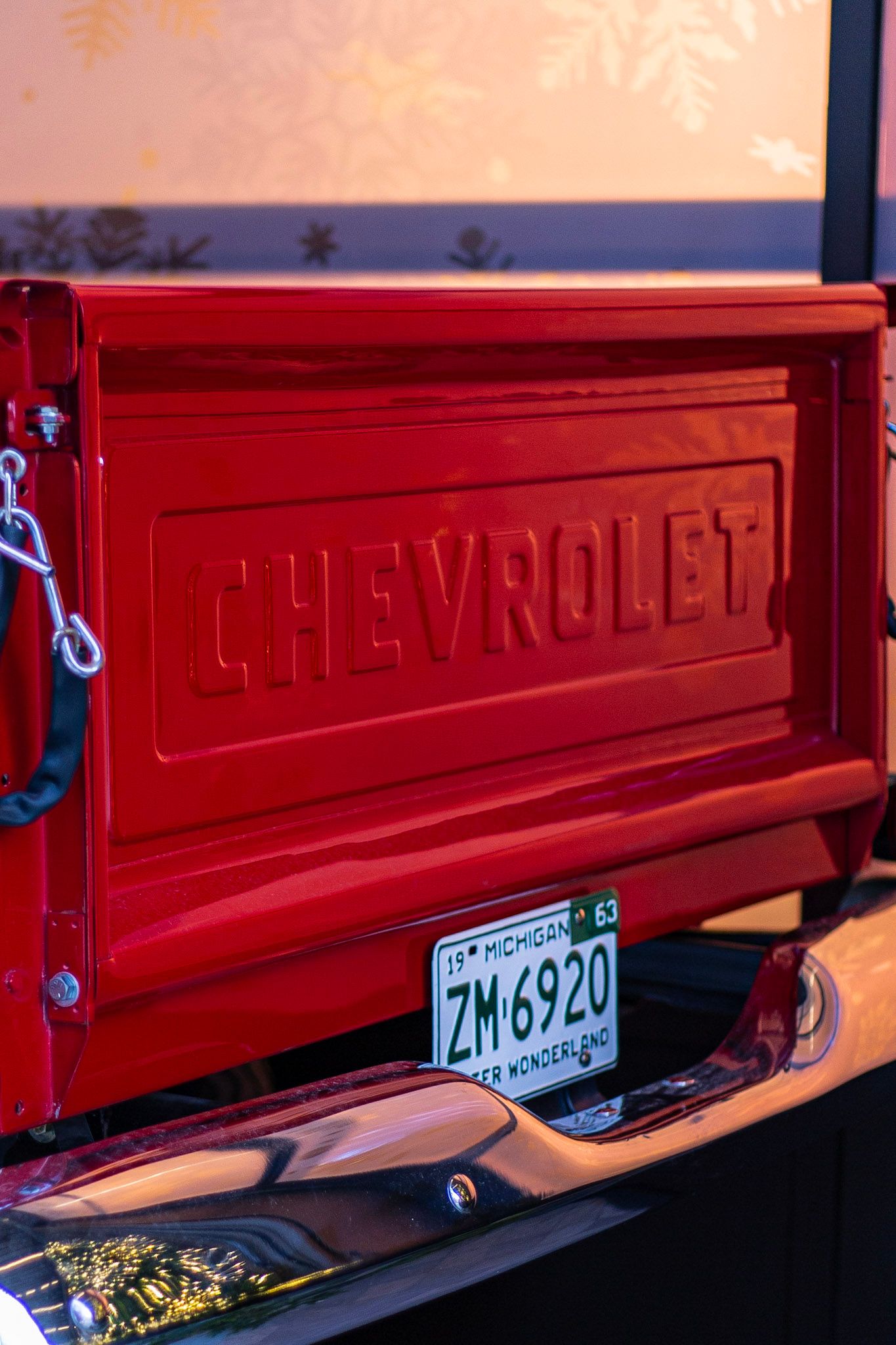 Rear tailgate of a classic red Chevrolet truck with Michigan ZM6920 Winter Wonderland license plate.